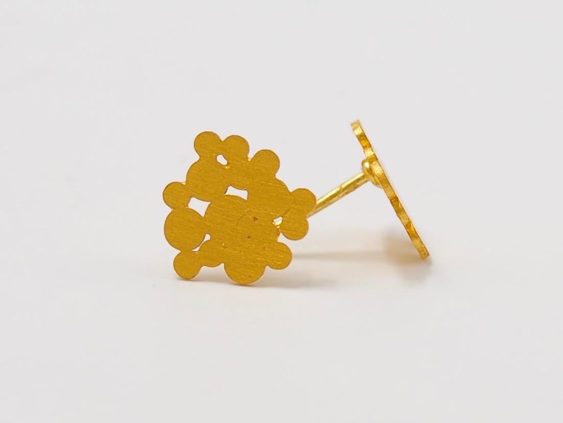 These simple stud earrings by Scrives in 22 karat gold are made of little disks of different sizes that are placed side by side in random ways. 
All single pieces are of different shapes.

These one-of-a-kind earrings are handmade with 22kt mat
