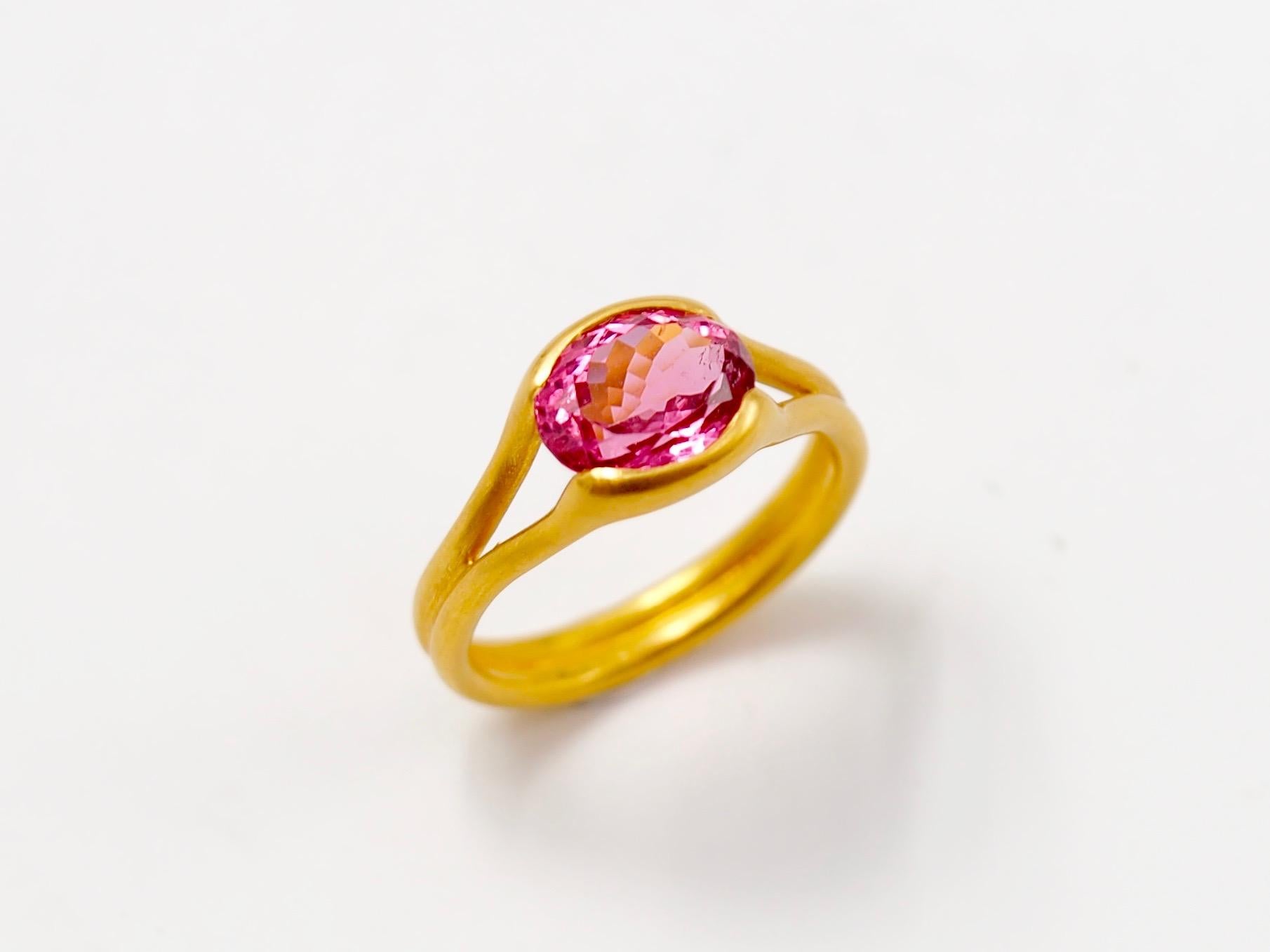 This delicate ring by Scrives is composed of an hot pink tourmaline of 2.38cts. 

The stone is hold by 2 gold lines that form the band. This design allows light to come into the stone from multiple directions and put into highlight the stone. 

The