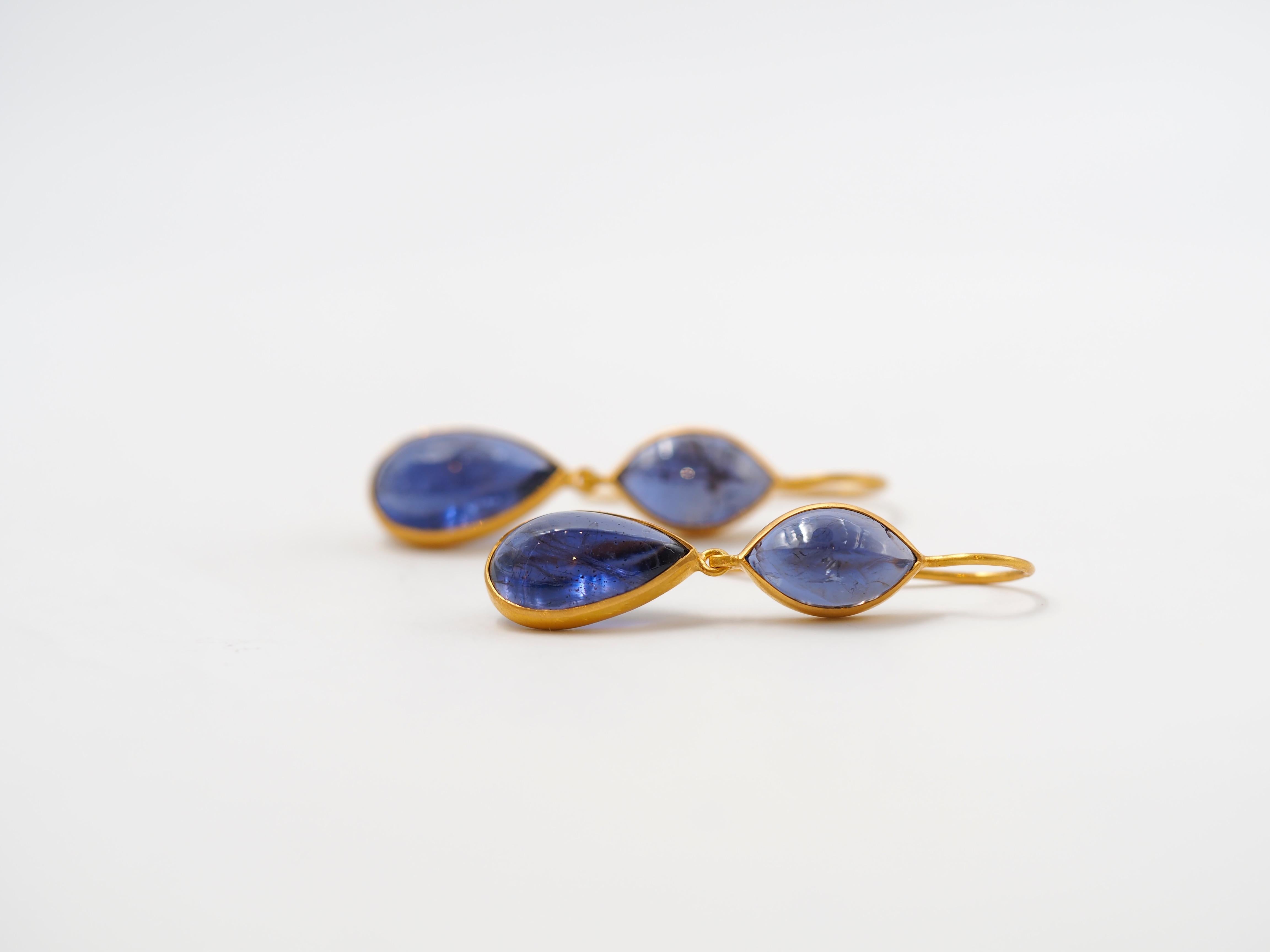 These earrings by Scrives are made of 4 iolite cabochons for a total weight of around 14.65 cts. The top stones have a marquise cabochon shape and the bottom stones are pear / drop shape large amethyst cabochons.  
The stones are simply set in 22