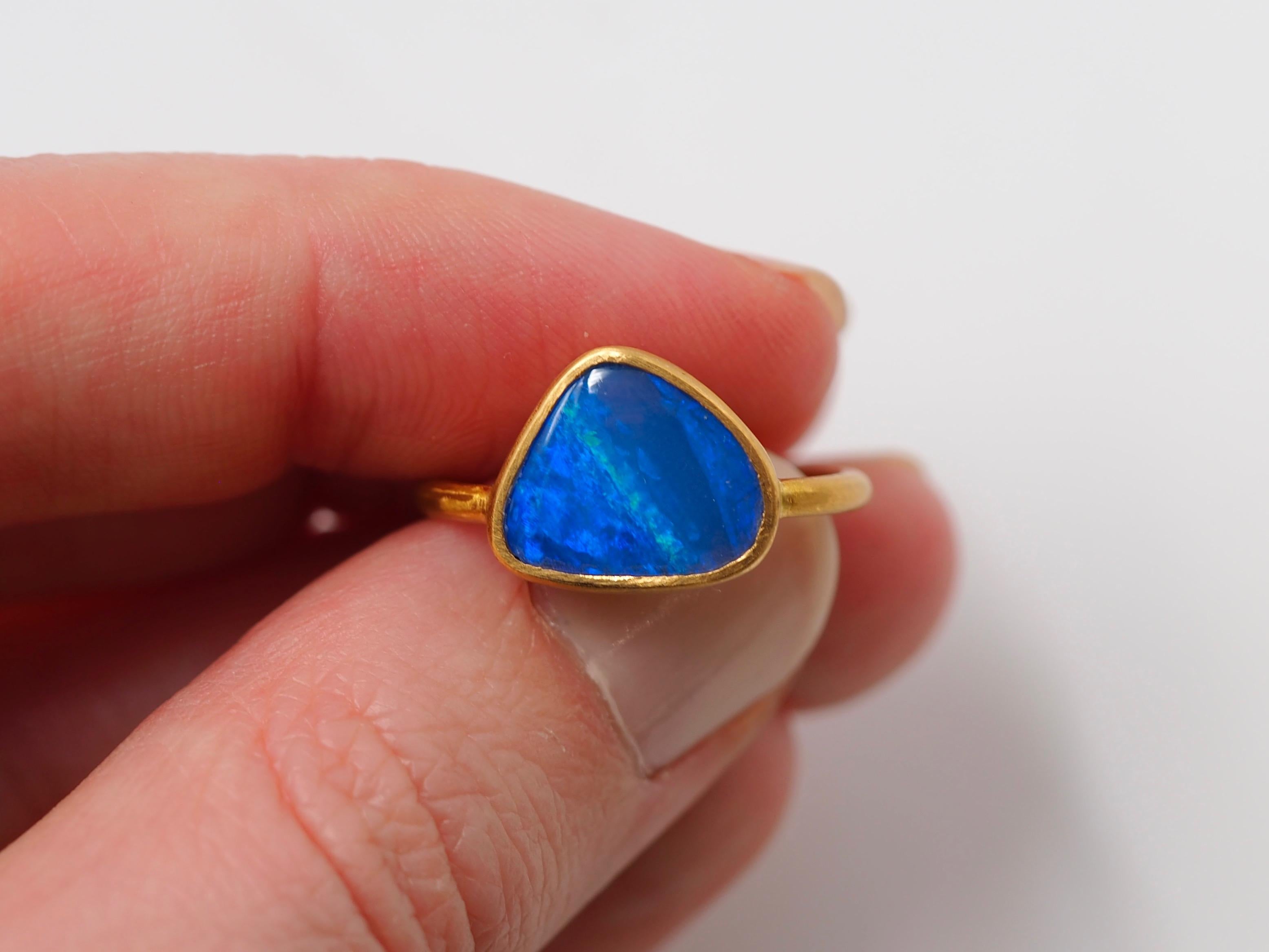 This simple ring by Scrives is composed of a blue and green opal cabochon of 2.7 cts. The stone has an irregular shape. Different blues are visible and an intense green line go from a side to the other.

This opal is natural and is a doublet which