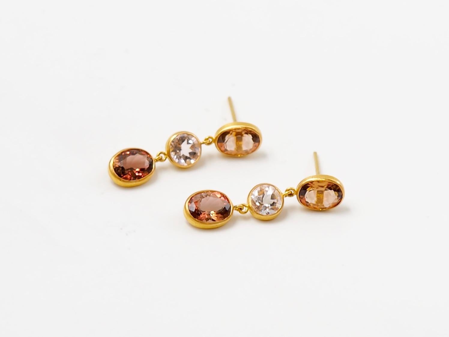 These classique earrings by Scrives are composed of 4 ovales tourmalines (2 orange & 2 peach) & 2 round light  morganites. The unusual colour of the tourmalines combined with the morganite bring a modern look to these earrings. 
Tourmalines &