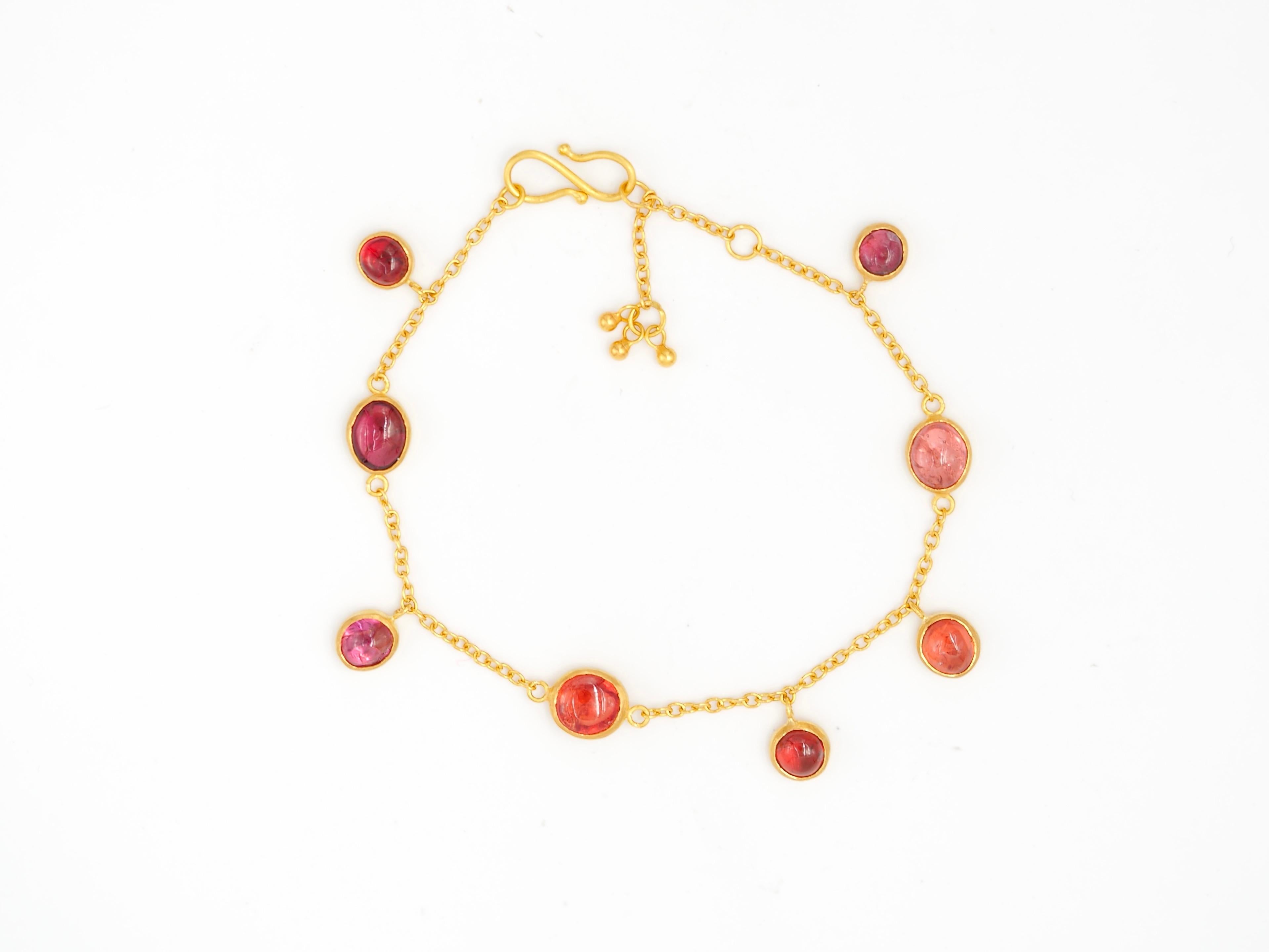 On this bracelet by Scrives, 8 natural spinel cabochons are simply set with a closed gold culet. The total weight of spinels is 8.06cts. They are natural, untreated spinels from Myanmar. 
Three stones are fixed on a fine gold chain and 5 are