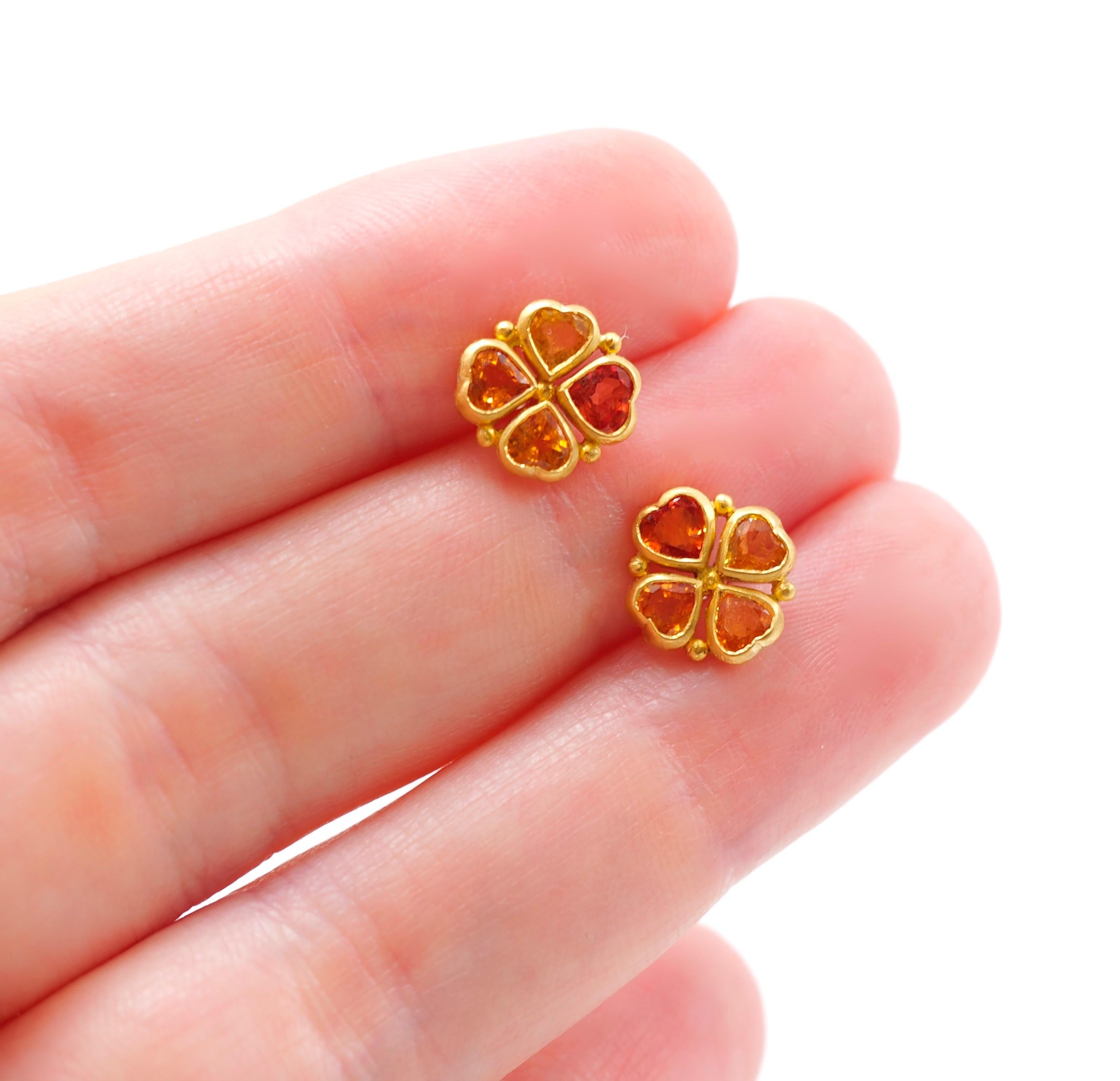 These earrings by Scrives are composed of 4 hearth shape sapphires (total weight of 1.38 cts). All 4 stones have different shapes and colours / hues from yellow to strong orange. 

The stones are set in gold (closed setting) and in the gaps, a gold