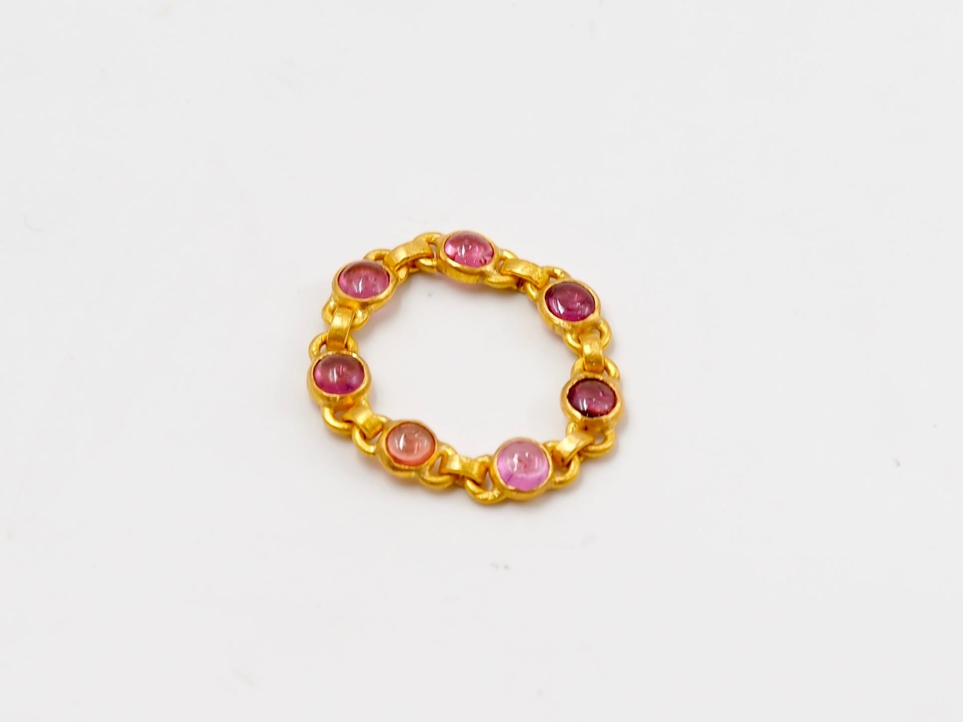 This ring by Scrives is made of 7 spinel cabochons set in 22 karat Gold. The colours of the spinels range from pink to light purple. The spinel are natural and untreated from Myanmar / Burma. 
The ring is like a chain, flexible and very confortable