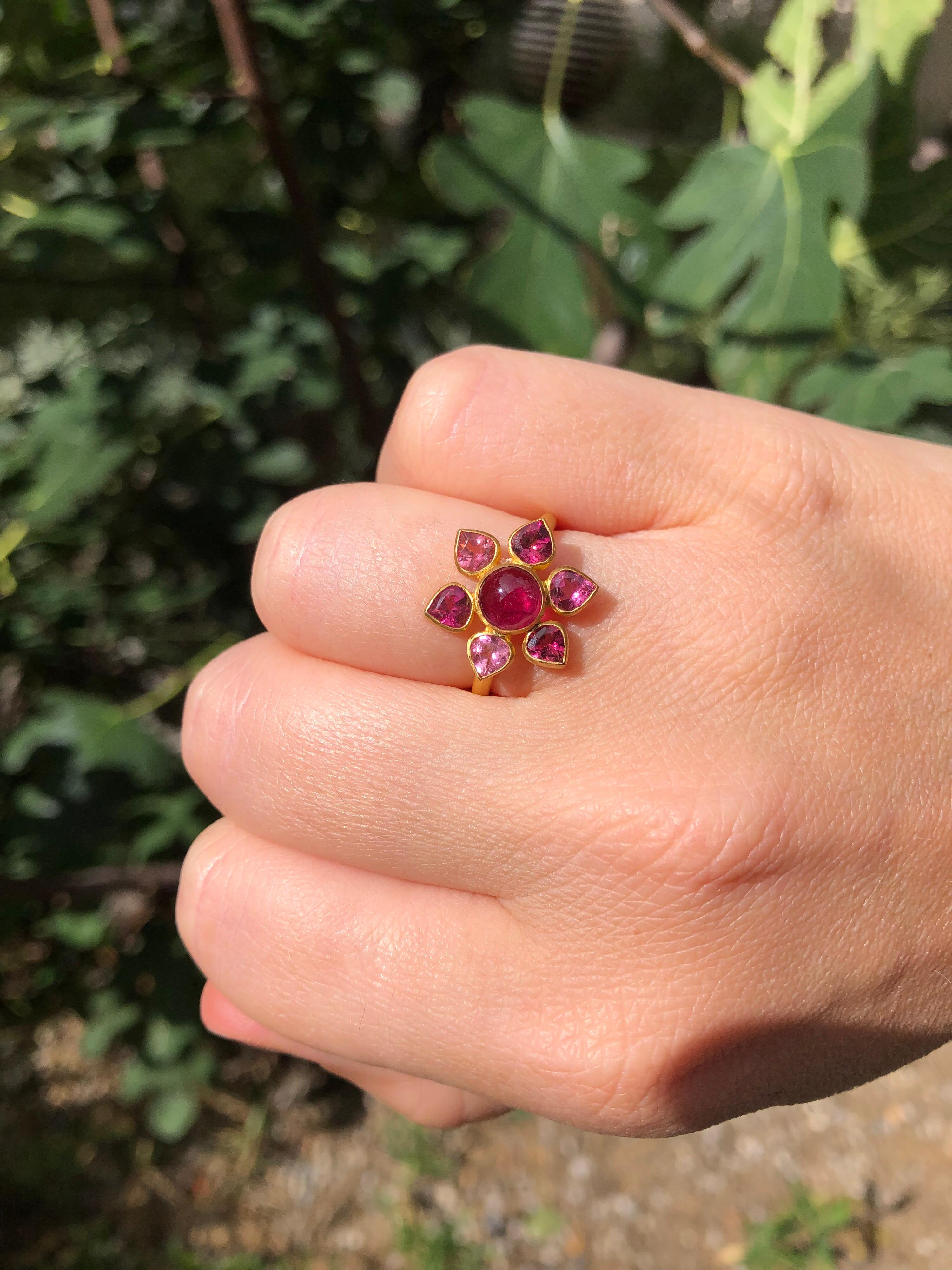 Scrives Flower power ring is composed of a round pink tourmaline cabochon surrounded by 6 pear shape faceted tourmalines of various hues. 

The stones are natural untreated tourmalines and show natural typical inclusions. 

This one-of-a-kind ring
