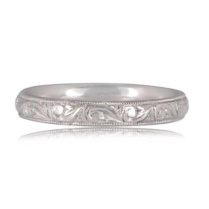 An exquisite platinum band exuding antique charm, adorned with intricate scroll-motif hand engravings. The engravings are elegantly bordered by rows of fine milgrain, creating a captivating design that gracefully wraps around the entire band.

Ring