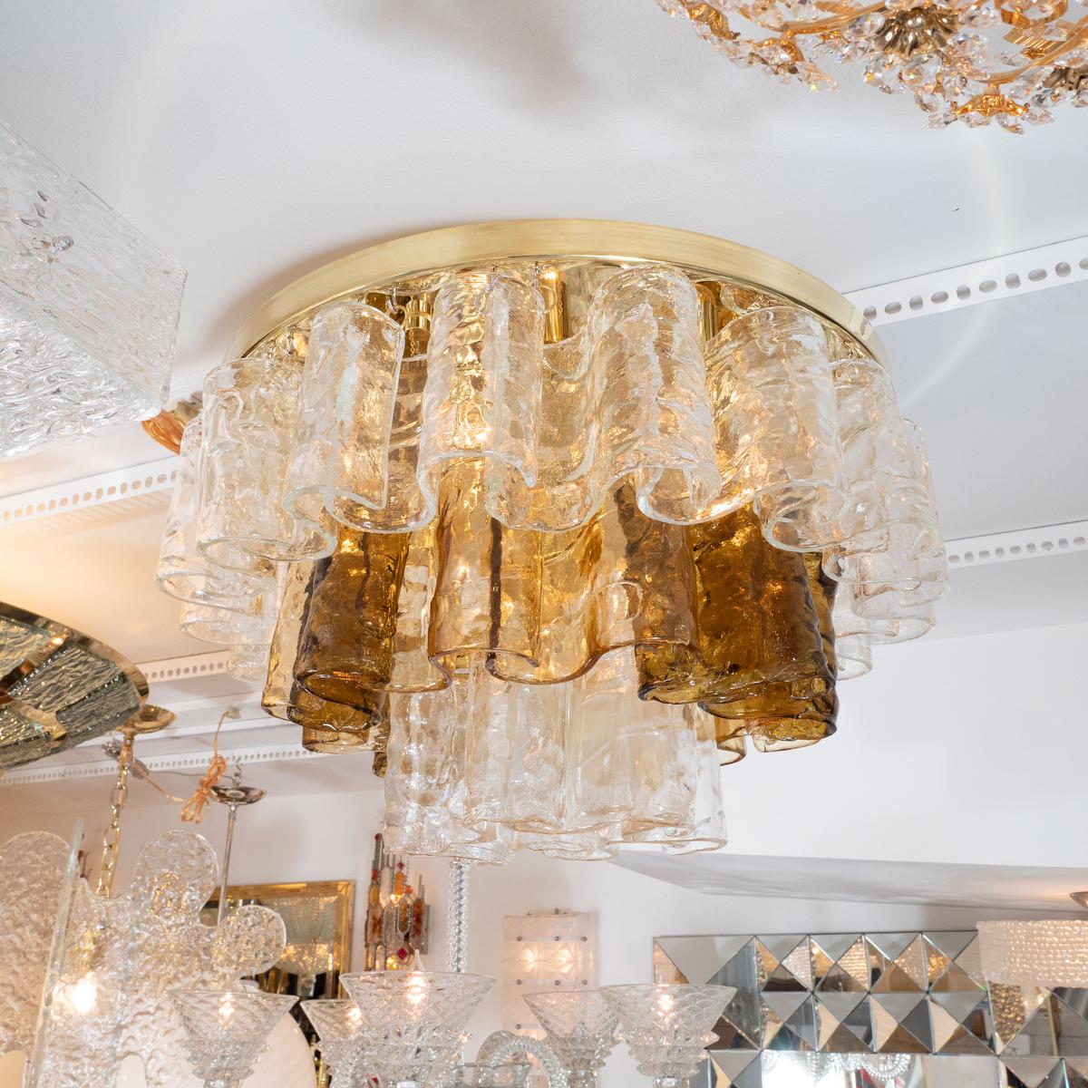 Brass flushmount fixture composed of suspended clear and amber scrolled Murano glass elements by Mazzega.