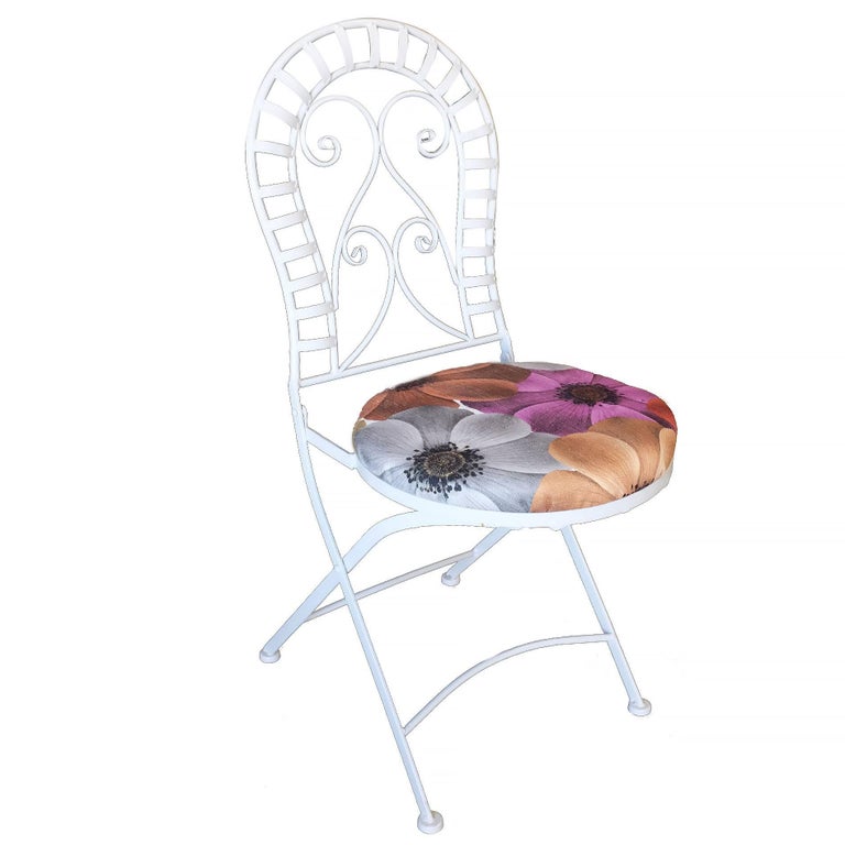 Woodard style scrolling cast iron folding patio/outdoor chairs with floral print seat cover and decorative rounded back.