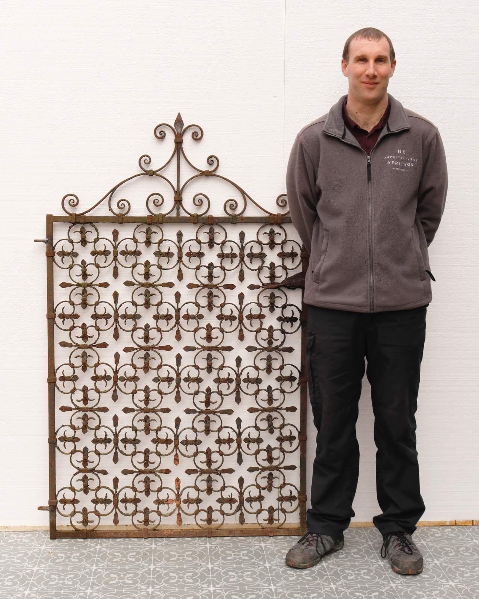 An elaborately crafted Victorian wrought iron side gate, detailed with repeating quatrefoils and a scrolling spearhead finial to the top. Dating from the late 19th century, it has stood the test of time for over a century, today making a stunning
