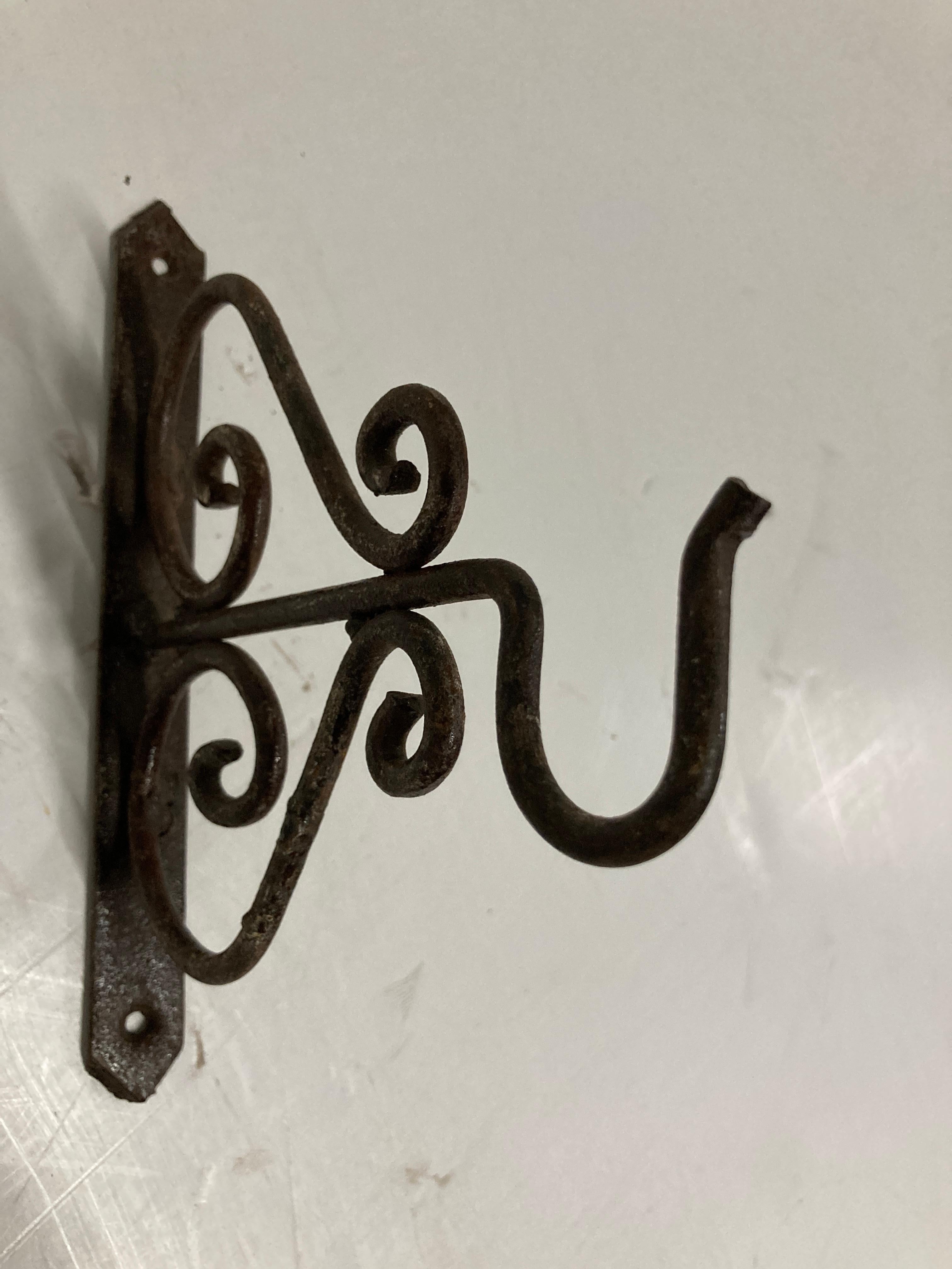 Hand crafted iron scroll design wall bracket. 
Wrought iron handcrafted wall-bracket for lanterns or signs.
Perfect for hanging lights or plants outdoors.
Scrolling wall-mounted brackets.
Multiple available.
Dimensions: Projection: 6