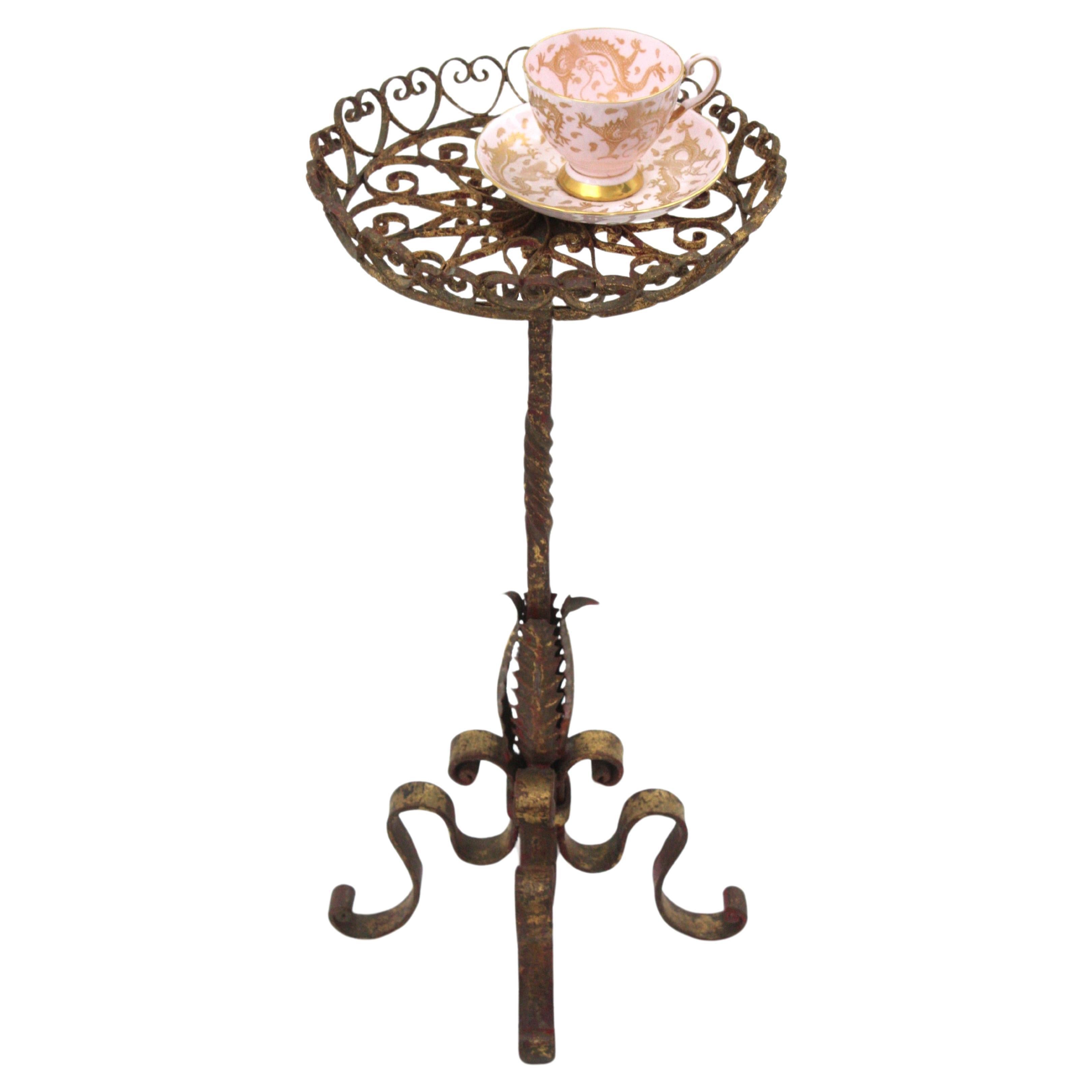 Table ronde de guéridon en fer forgé doré avec plateau à volutes, Espagne, années 1950
Le dessus est composé d'un ensemble de pièces en forme de cœur en fer enroulé, créant un effet magnifique. Il repose sur une base à quatre pieds avec des accents