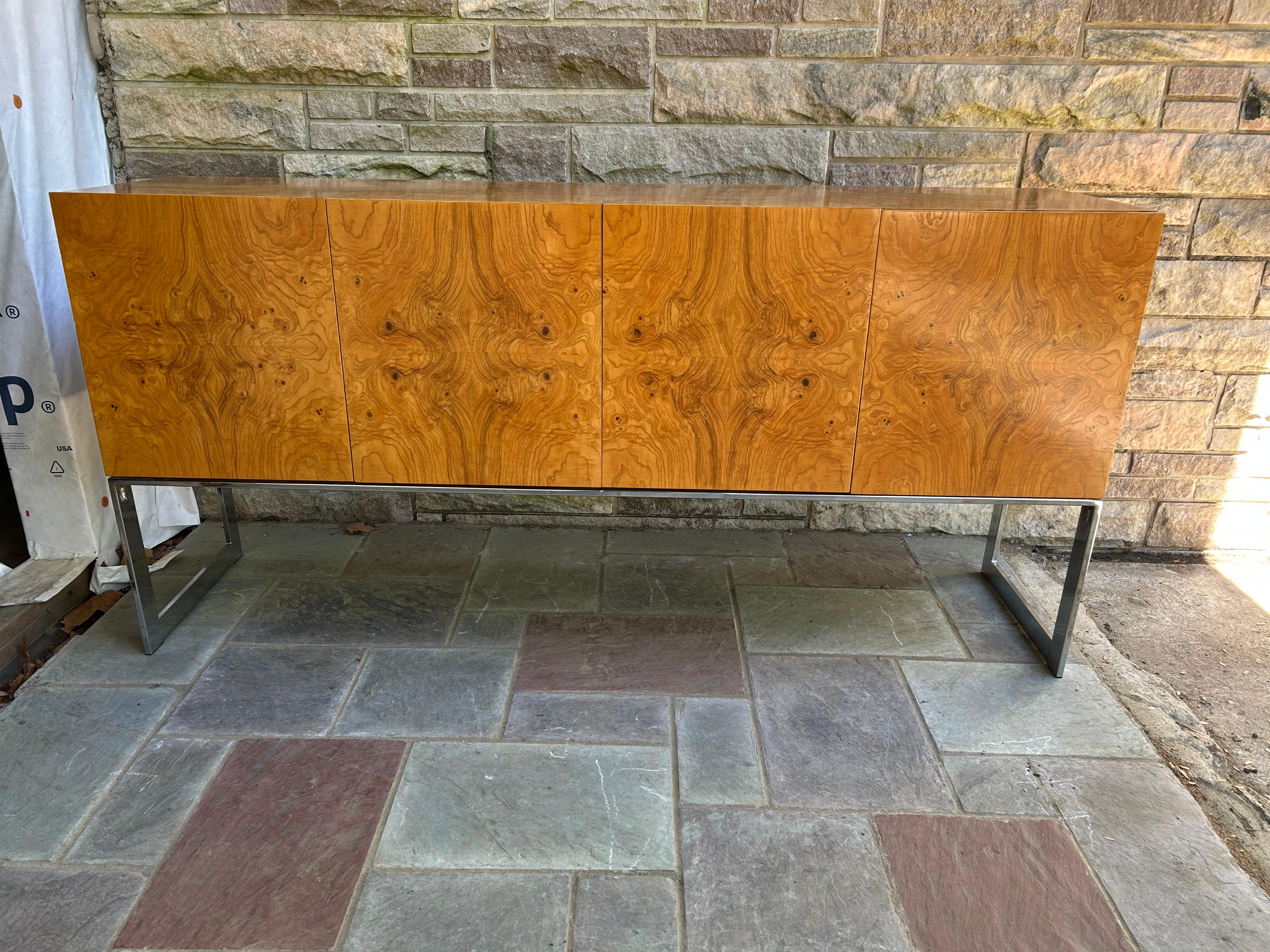 Magnífico aparador Milo Baughman de madera de olivo burilada y cromo. Esta pieza en concreto está en muy buen estado vintage, uno de los más bonitos que hemos tenido en mucho tiempo. ¡Tiene los separadores de cubiertos de terciopelo naranja en los