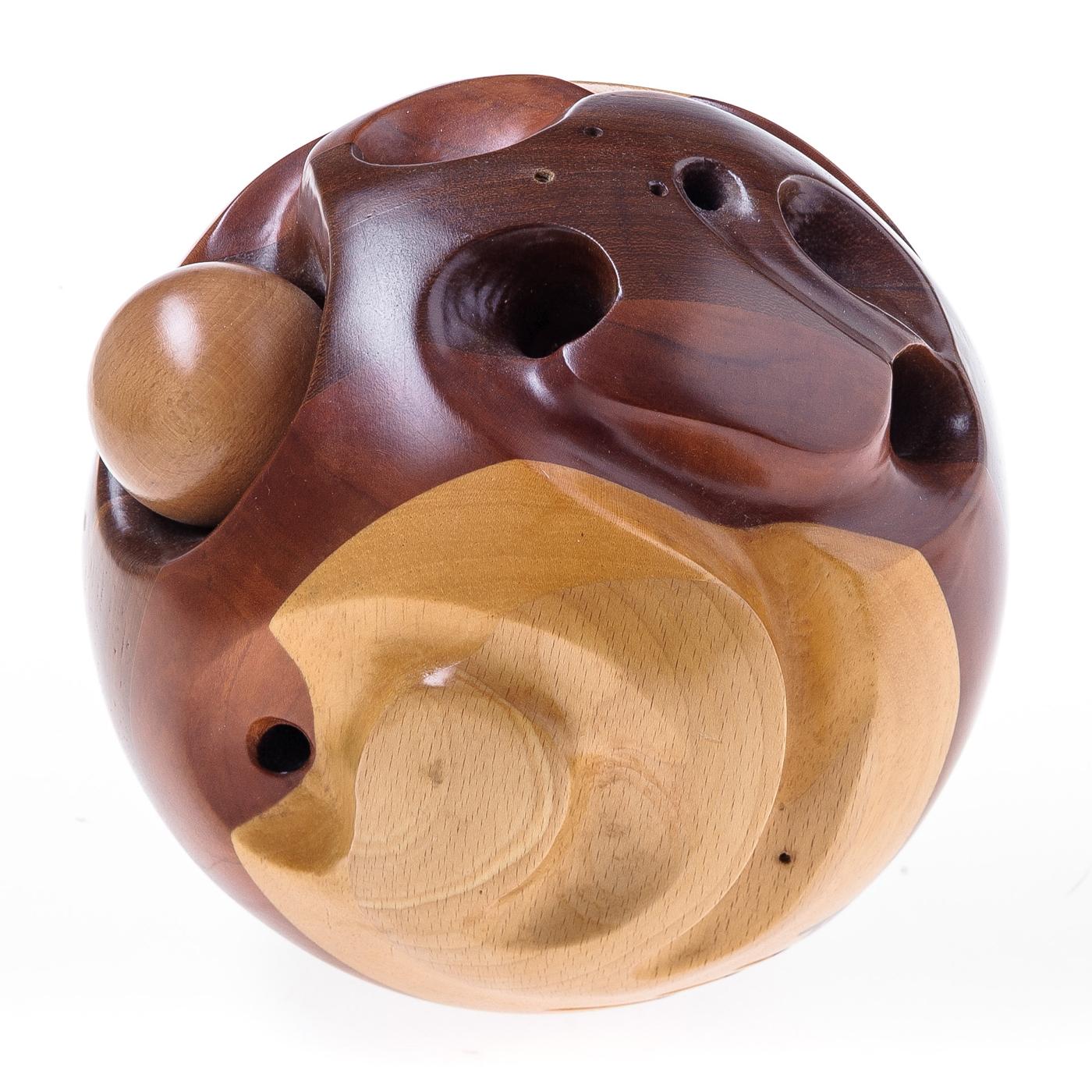 Merging sculpture and design, this handmade piece is a testament to masterful craftsmanship that celebrates the effortless elegance of wood. Entirely handcrafted, this sphere is composed of layers of prized woods, whose contrasting light and dark