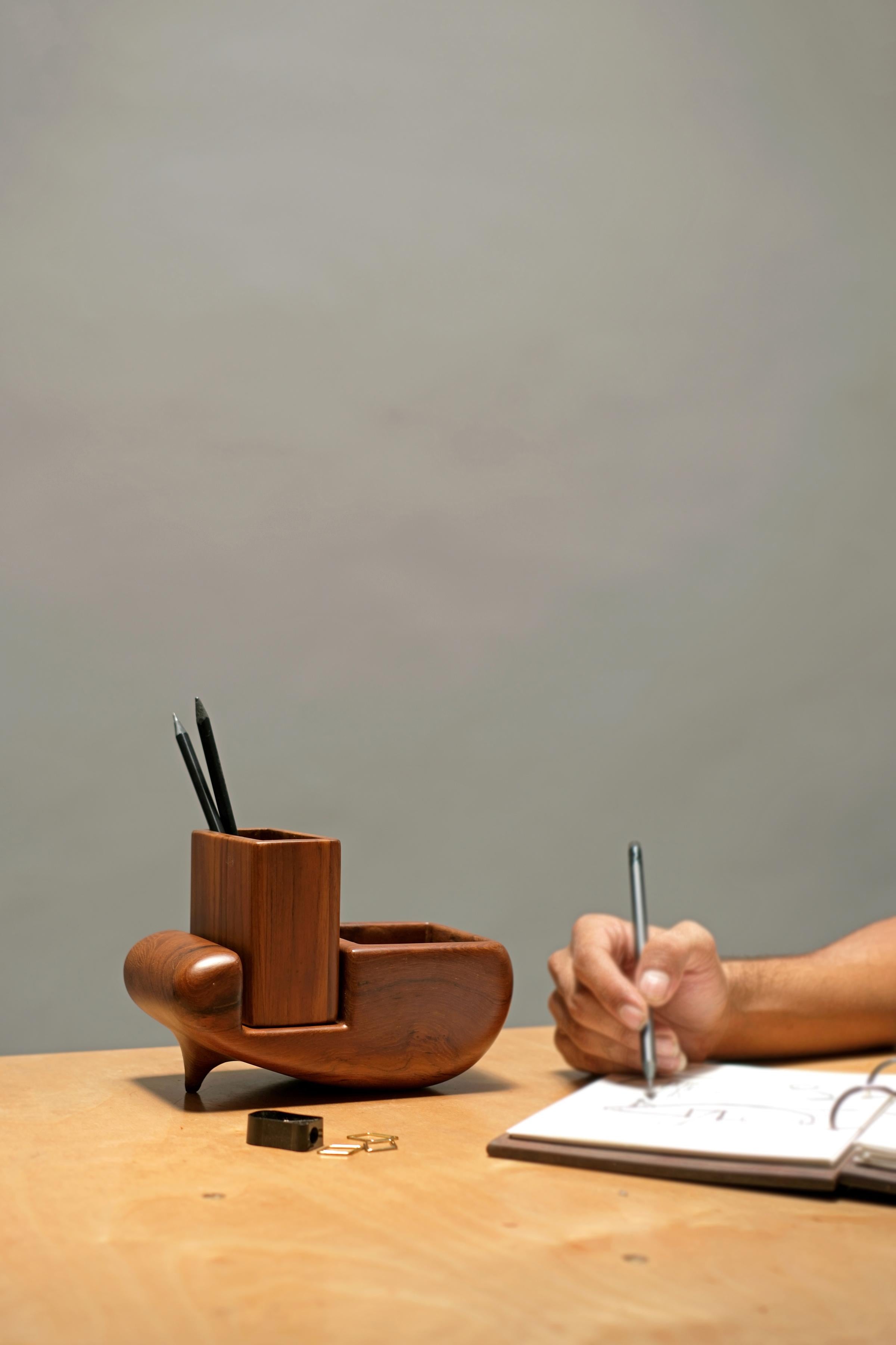 Sculp Stationery Holder by Studio Indigene
Dimensions: D 19.68 x W 10.16 x H 13.33 cm
Materials: Reclaimed Teak Wood.
Colors Brown, Natural Wooden Finish.

The Sculp Stationery Holder, made from reclaimed teak, is a visually stunning addition to any
