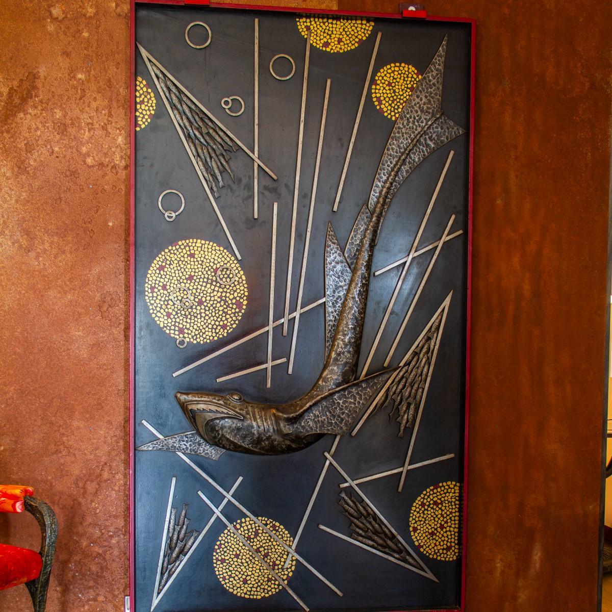A remarkable and rare sculpted and cast metal panel by Michel Zadounaisky, depicting a silver patinated shark surrounded with shoals of fish and abstract metalworks. The whole panel is framed in red steel and signed and dated within the scene