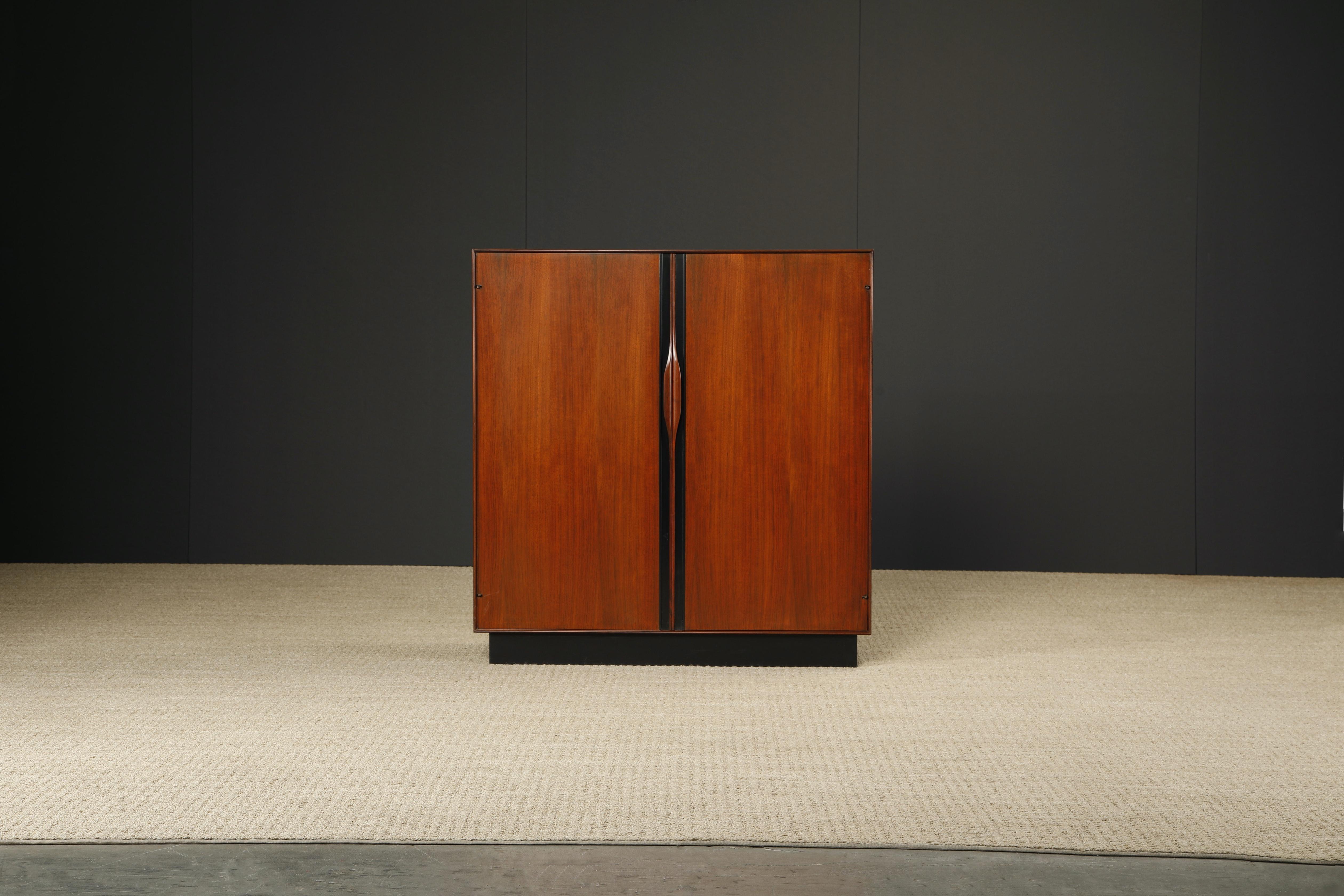 This beautiful Mid-Century Modern walnut armoire cabinet was designed by John Kapel for Glenn of California. Designed and produced in the 1960s, this example is signed with a Glenn of California medallion in one drawer. 

This beautiful bedroom
