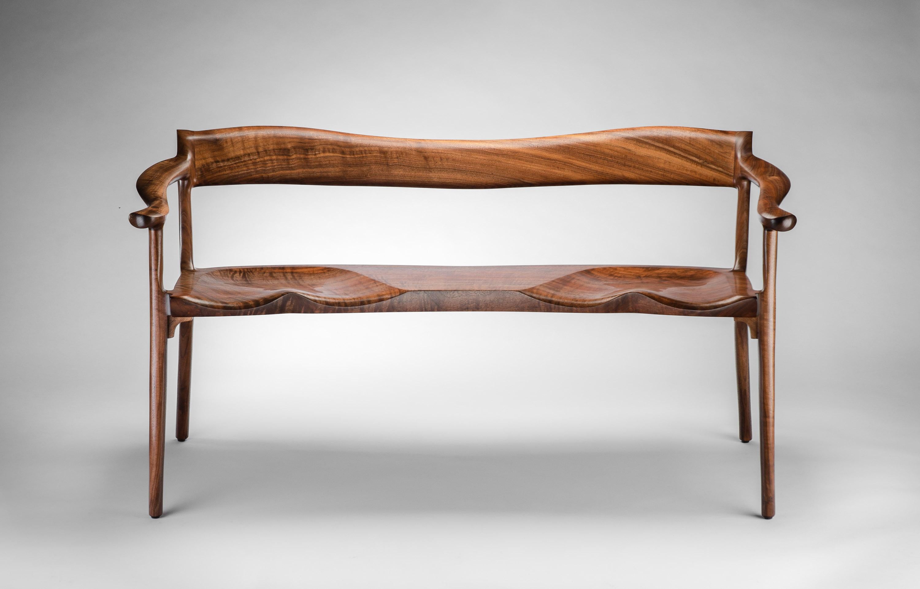 Le canapé Sumi d'Erickson Woodworking est un banc entièrement sculpté pour deux personnes, avec un dossier bas et des courbes continues qui sont aussi agréables au toucher qu'à l'œil. Chaque canapé est fabriqué à la main, un par un, en utilisant les