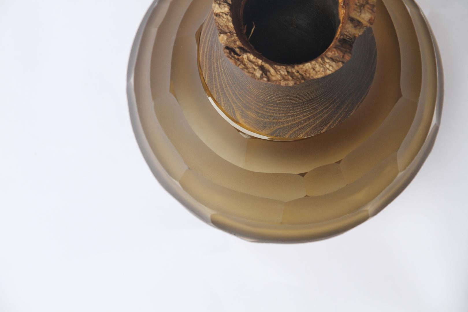 Sculpted blown glass and brass vase - Pia Wüstenberg
Dimensions: Height 30cm, diameter 23cm
Both rough and refined, this assortment plays with the multiple metamorphosis glass grants as a material. The glass is first handblown, and then cold