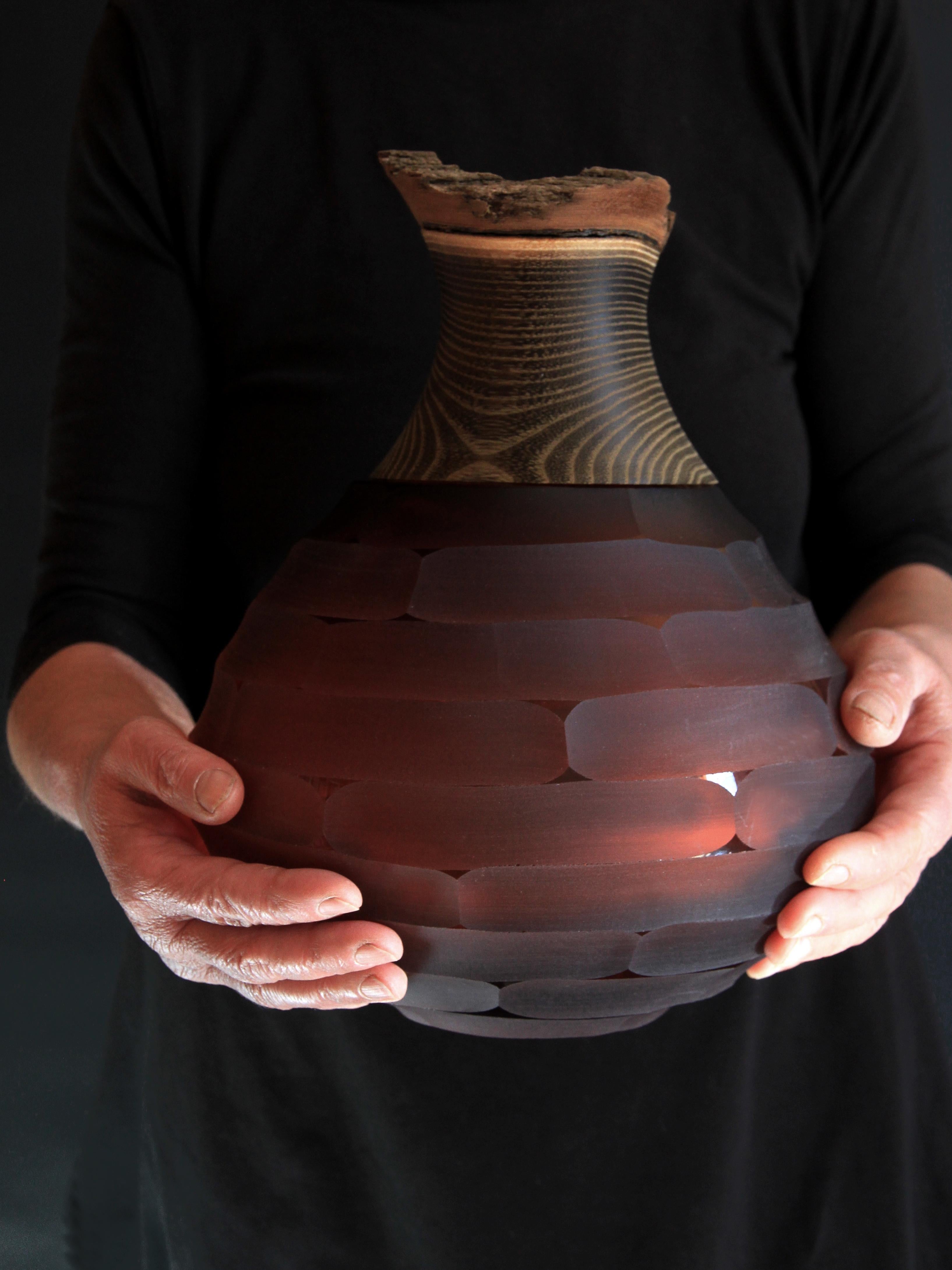 Sculpted blown glass and brass vase - Pia Wüstenberg.
Dimensions: height 30cm, diameter 23cm.
Both rough and refined, this assortment plays with the multiple metamorphosis glass grants as a material. The glass is first hand blown, and then cold