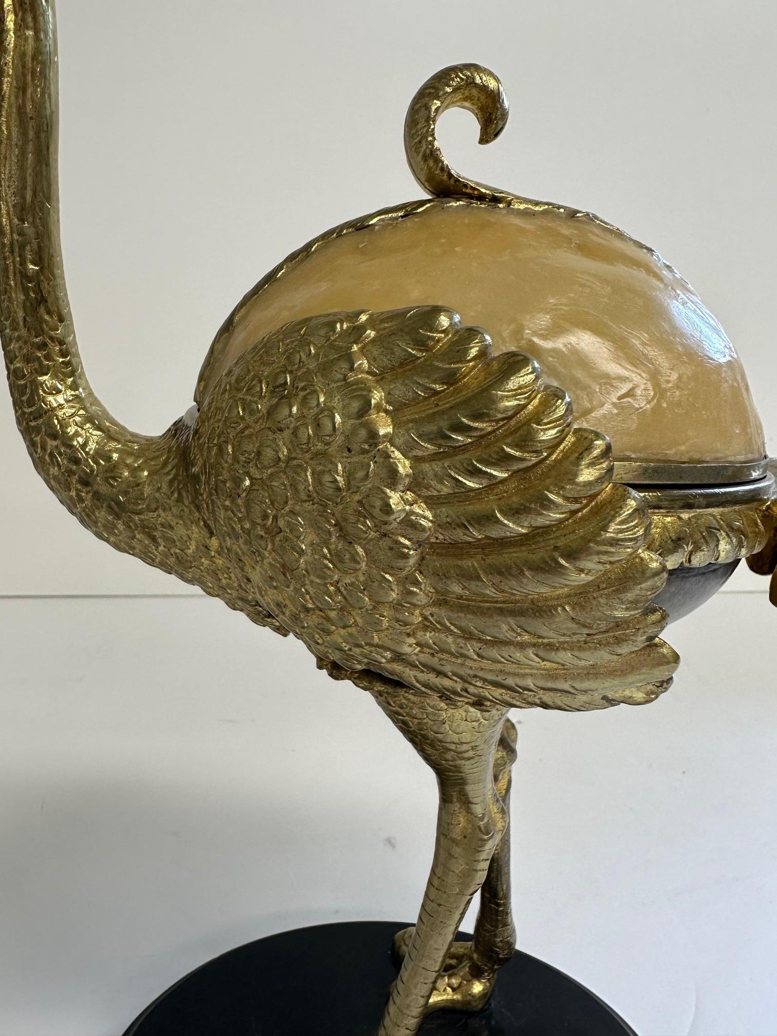 Unusual beautiful decorative box in the shape of a brass ostrich having rounded resin top and black marble base.