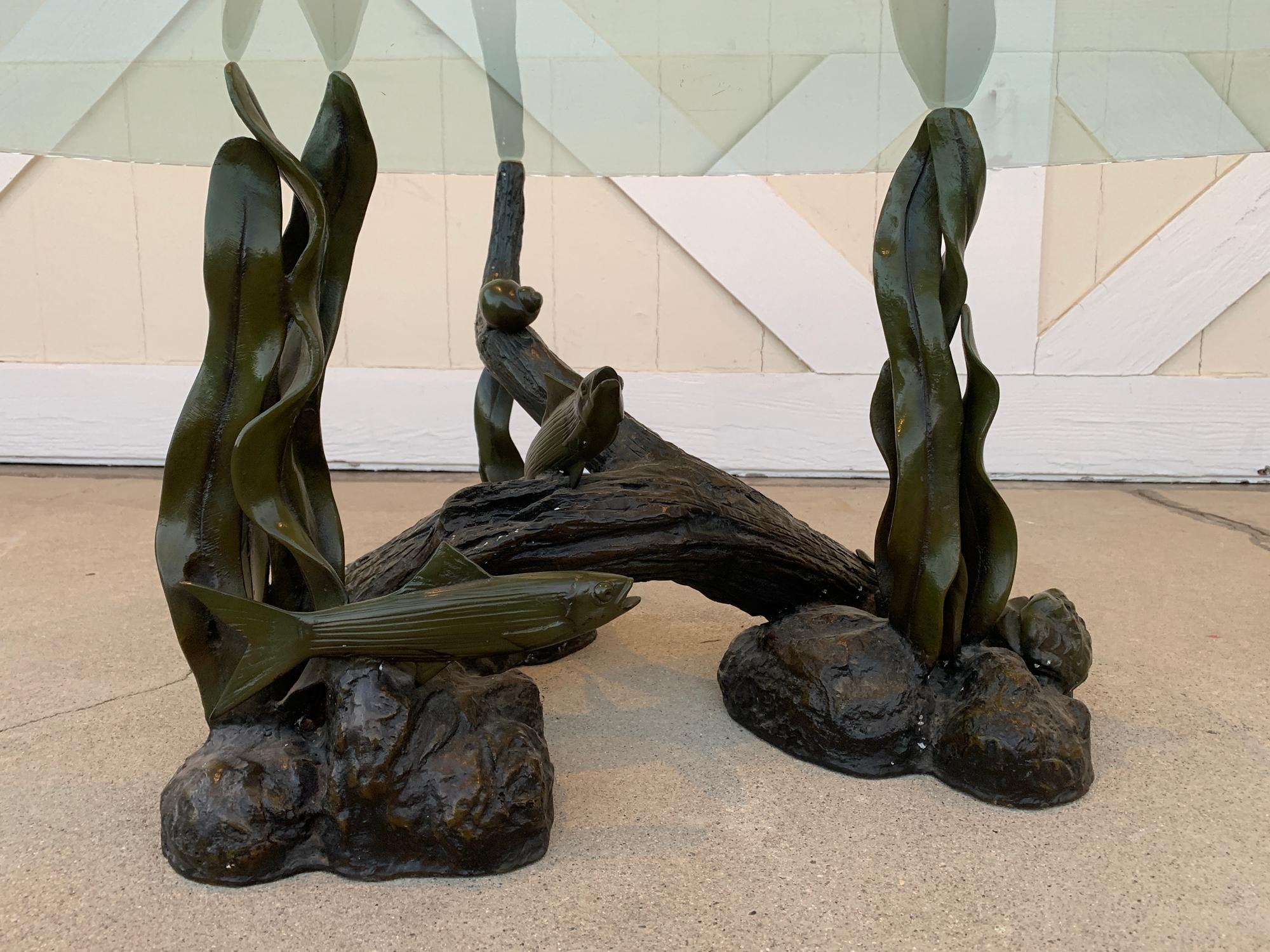 Beautiful bronze and glass coffee table depicting a sea creatures playing around a piece of coral and sea weed leaves, there you can see a couple of fish, snails, clams and a sea star.

The bronze has beautiful patina and a glossy finish to mimic