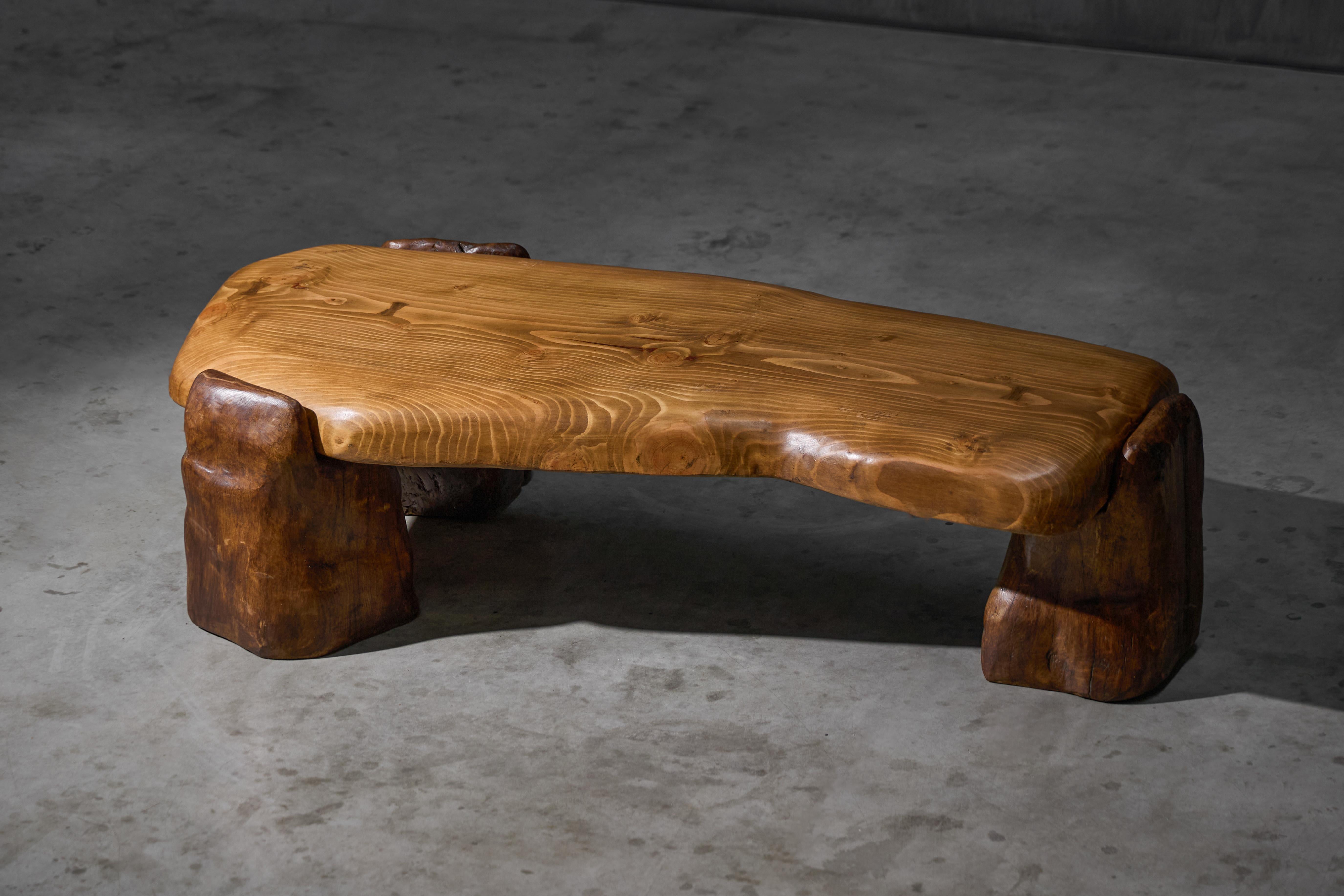 Fabricada en 2025 con madera maciza recuperada, esta mesa de centro tiene un tablero de pino macizo moldeado a mano con sutiles curvas y bordes suavizados. Descansa libremente sobre cuatro patas de roble macizo talladas a mano, sin ningún tipo de