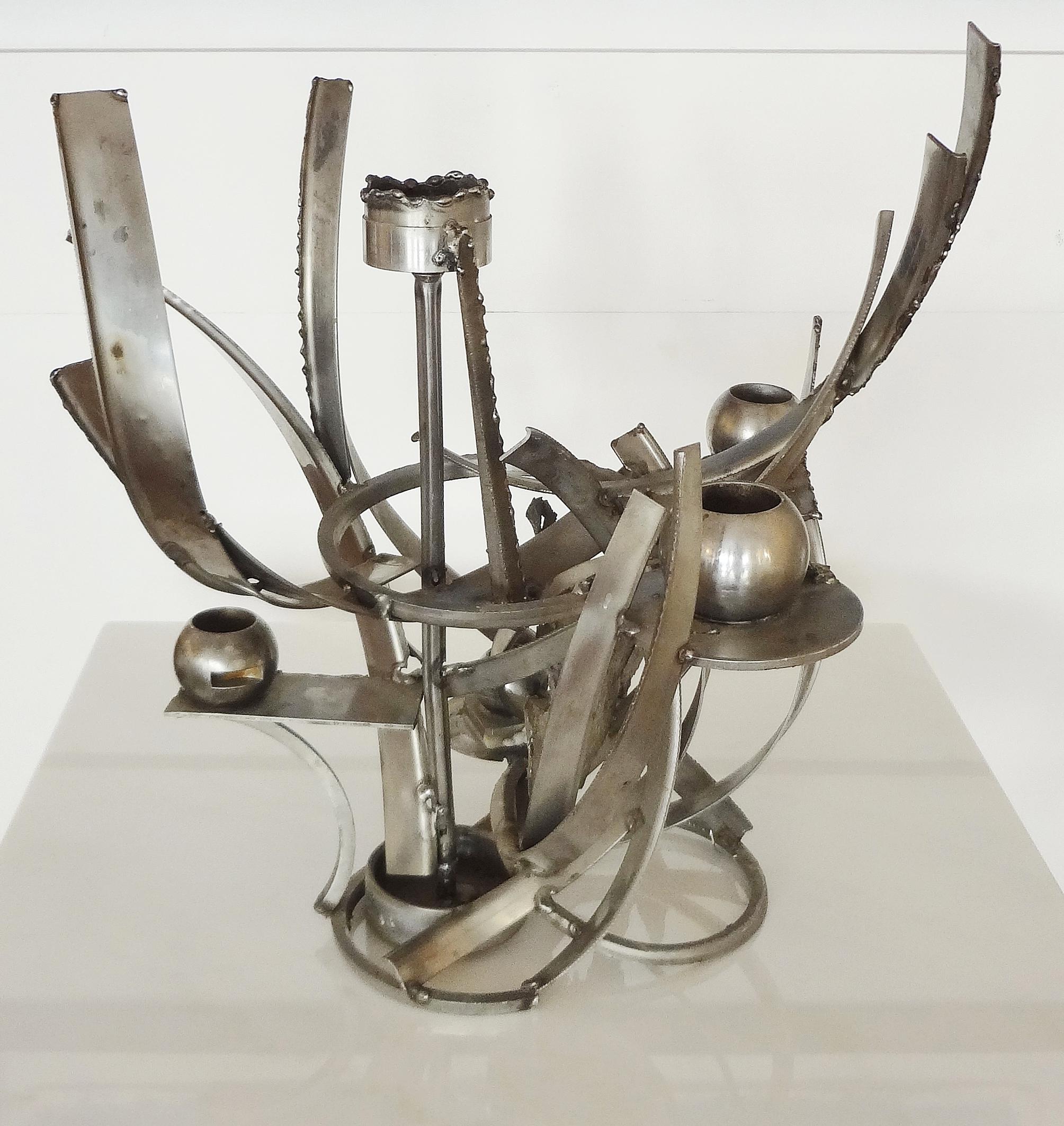 Albert Feraud (1921-2008)
Important carved and welded steel candleholder, circa 1970.
Five bobeches. Signed. Unique piece. 

Albert Féraud est un grand sculpteur français spécialiste du fer soudé et l’acier galvanisé. Après 3 écoles des