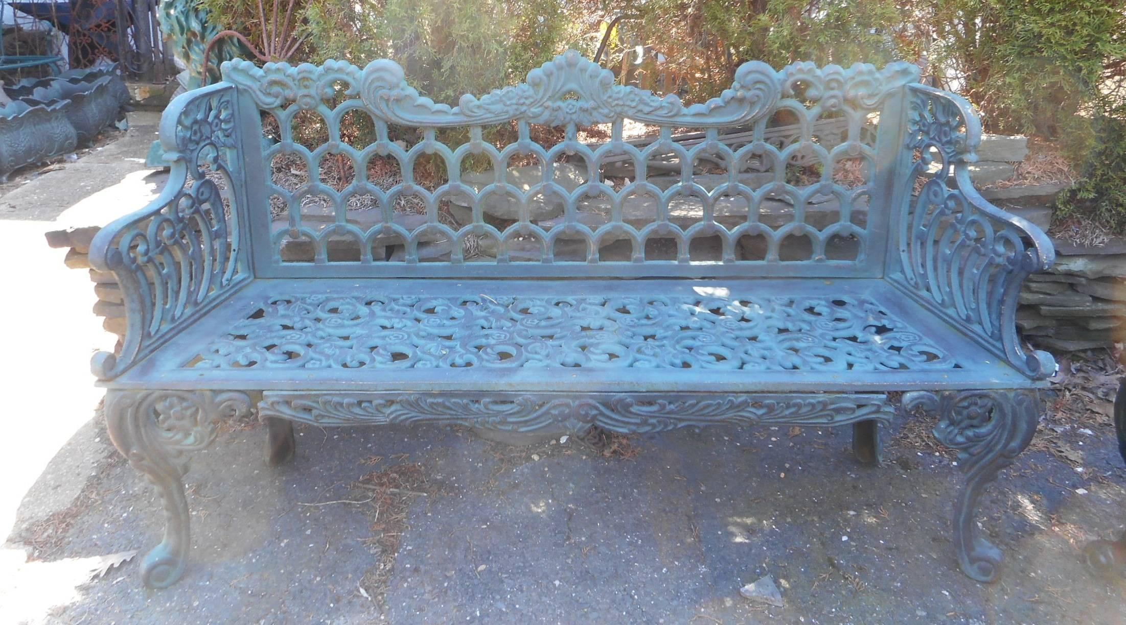 This beautiful cast iron bench features unusual designs on the legs, arm rests, and backrest. Unique design with four individual legs with splayed feet. The sculpted arm rests and wonderfully detailed seat are sure to make an impression in any