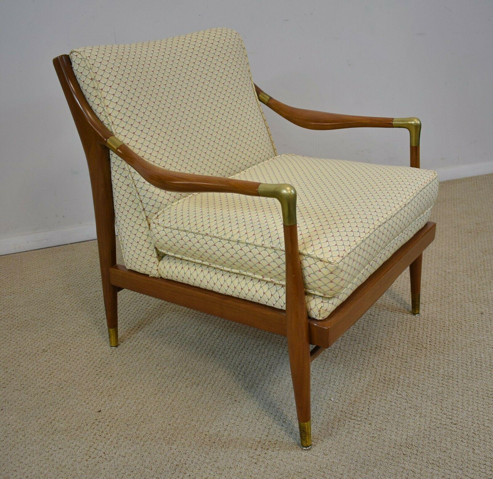 Sculpted Danish brass accented lounge chair attributed to IB Kofod- Larsen, circa 1960s. Curved upholstered back above upholstered seat. Tapered supports have brass feet. Chair is in very nice condition with slight wear. Chairs width is 26 1/2