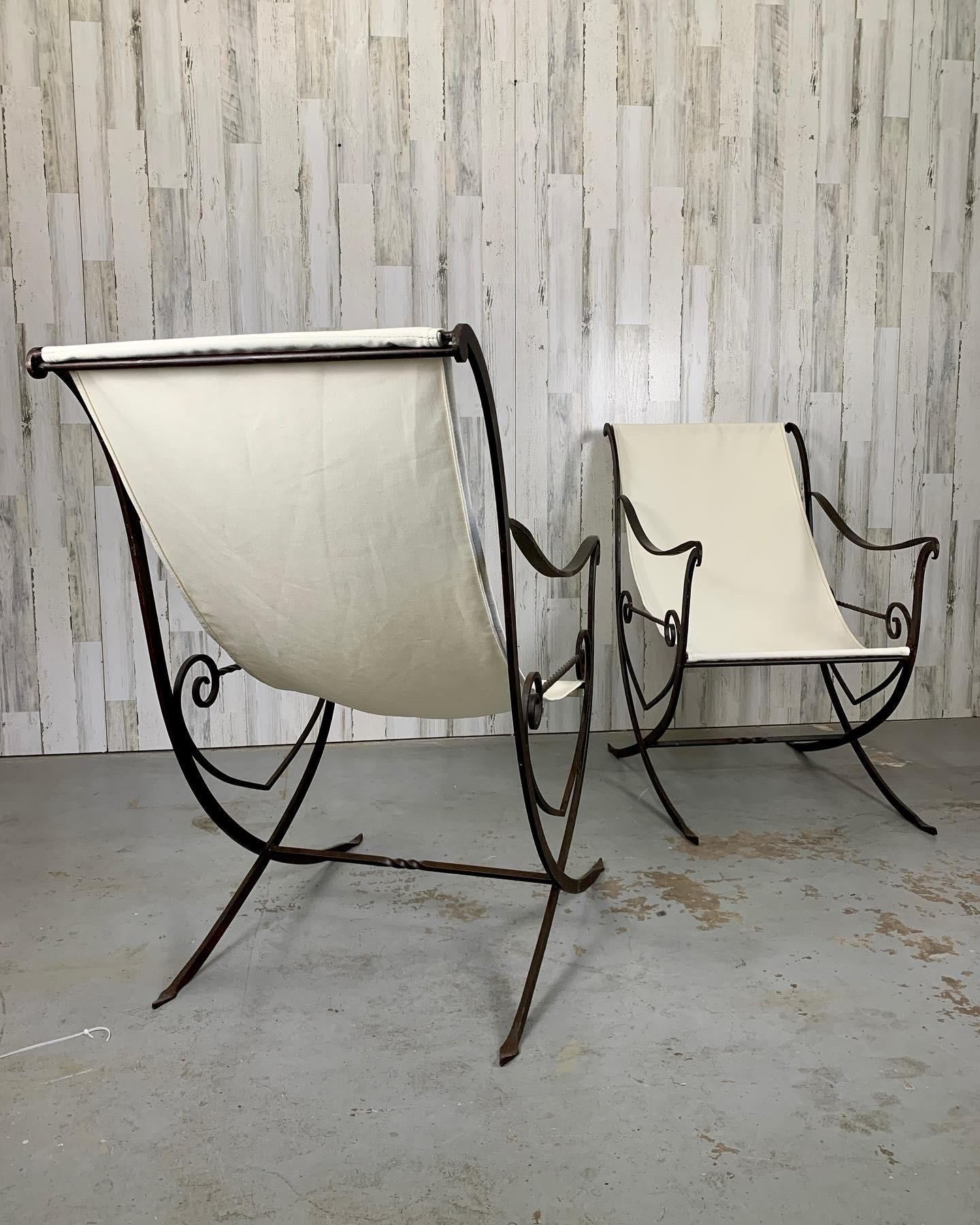 Sculpted hand wrought iron with new off-white canvas sling. Very rustic and elegant at the same time with some of the original pale green paint on the iron.
These can be used either inside or outside. 
Because they were hand made they are slightly