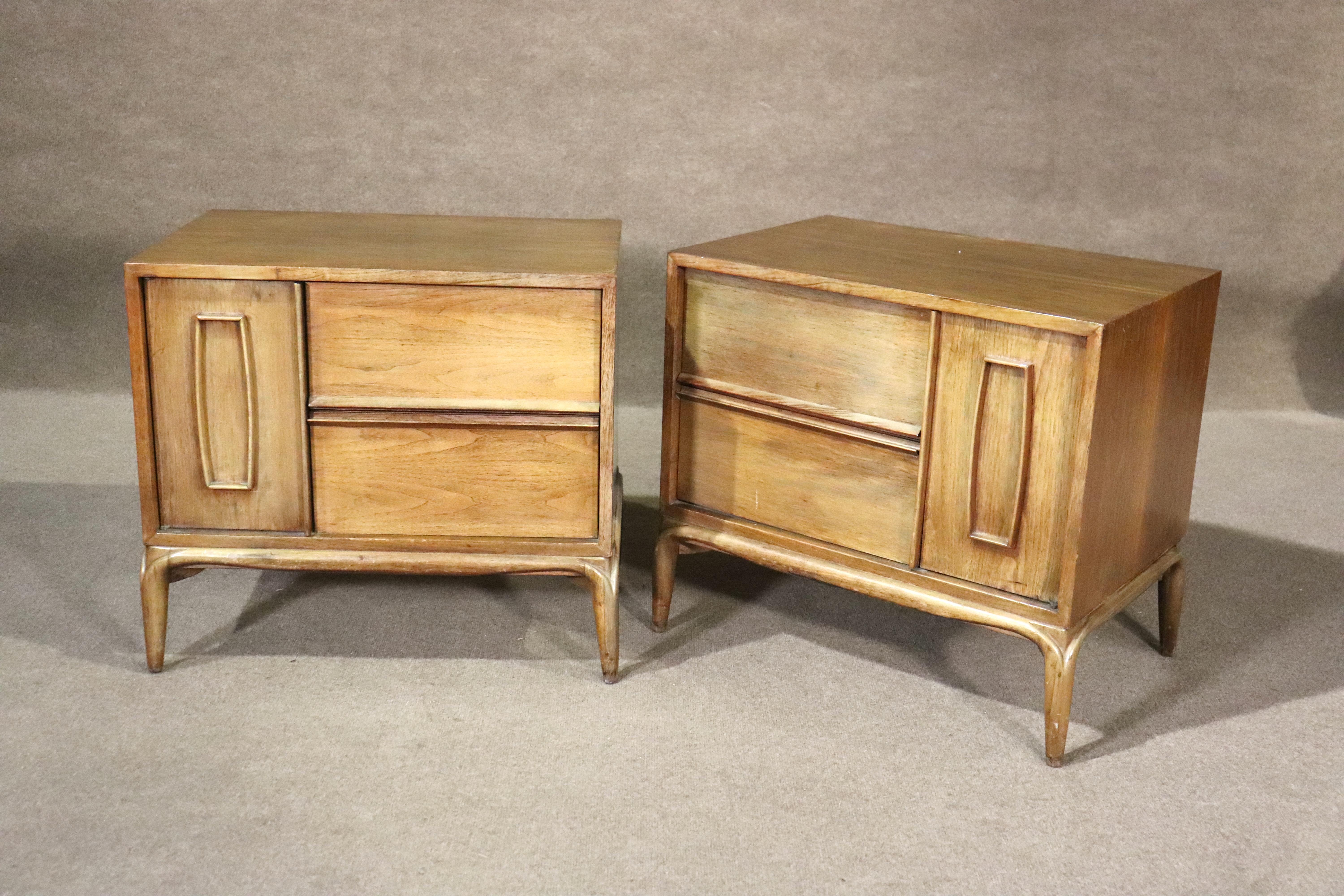 Mid-century modern end tables with storage. Sculpted front doors reveal cabinet space, and two drawers offer more storage. 
Please confirm location NY or NJ