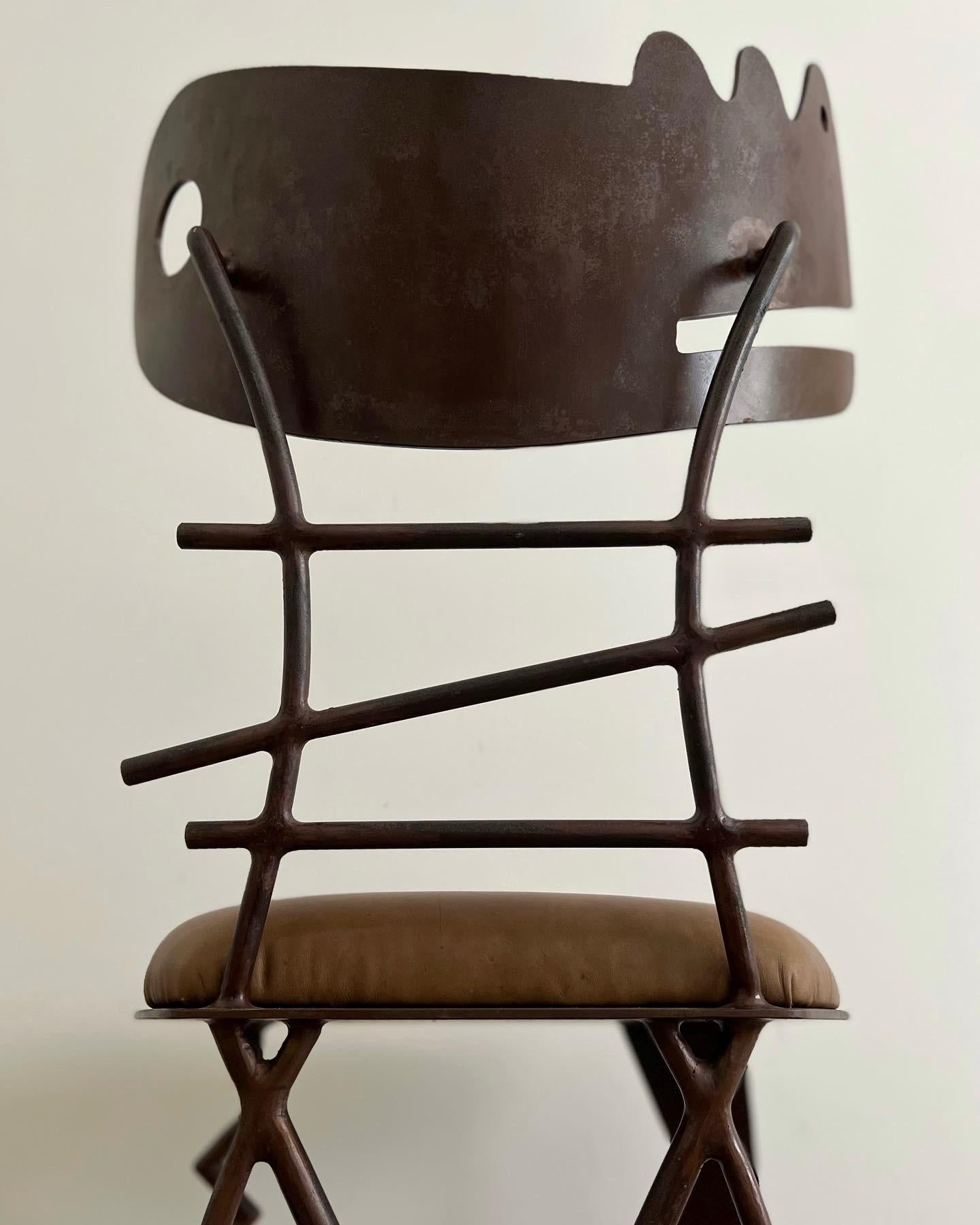 Offered is a Gregory Hawthorne iron chair crafted from welded metal. The seat was reupholstered in distressed brown, olive colored leather that is soft to the touch. The chair would function well as an accent chair or sculptural art piece in a