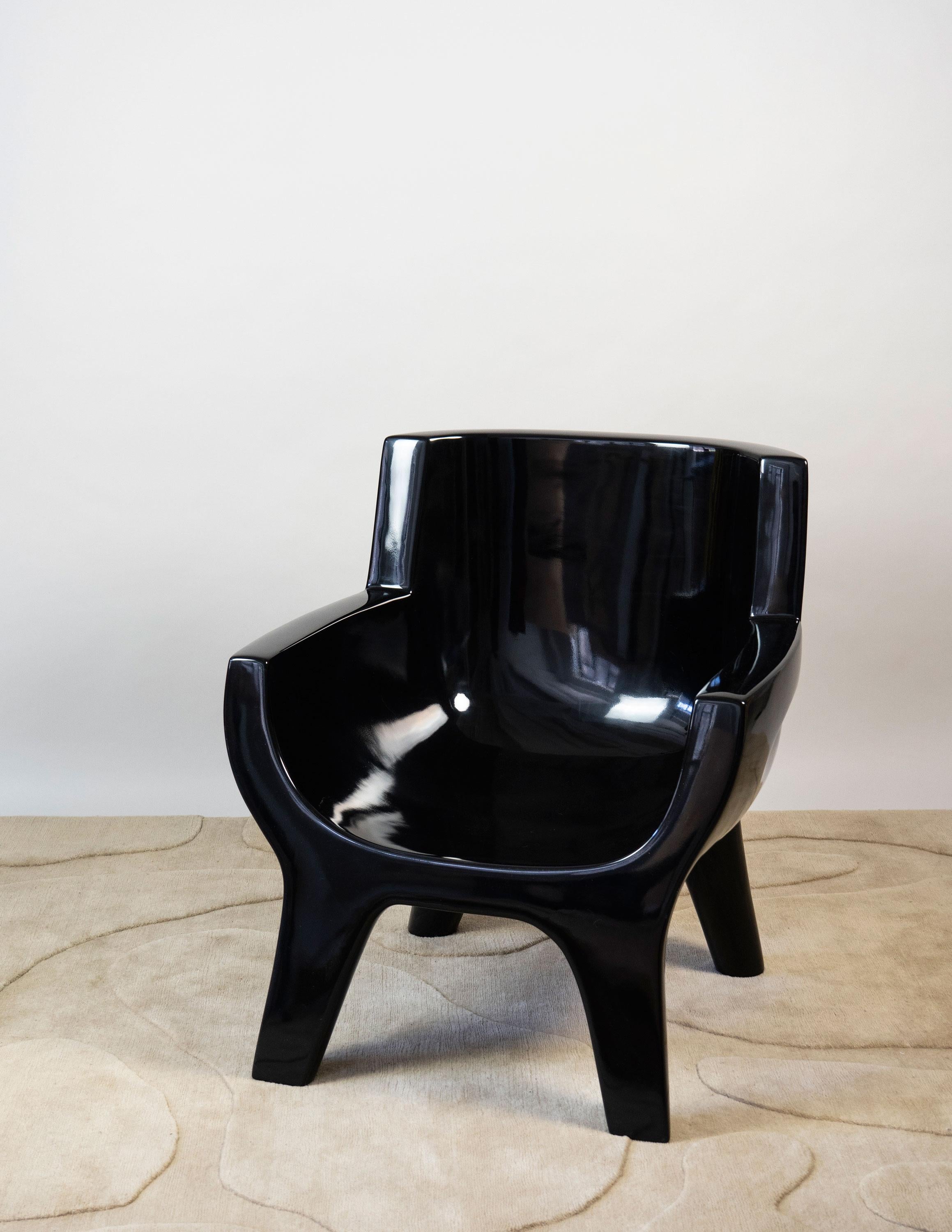 Sculpture / armchair carved by hand with two handles on each side. Comfortable and very sturdy black lacquer.