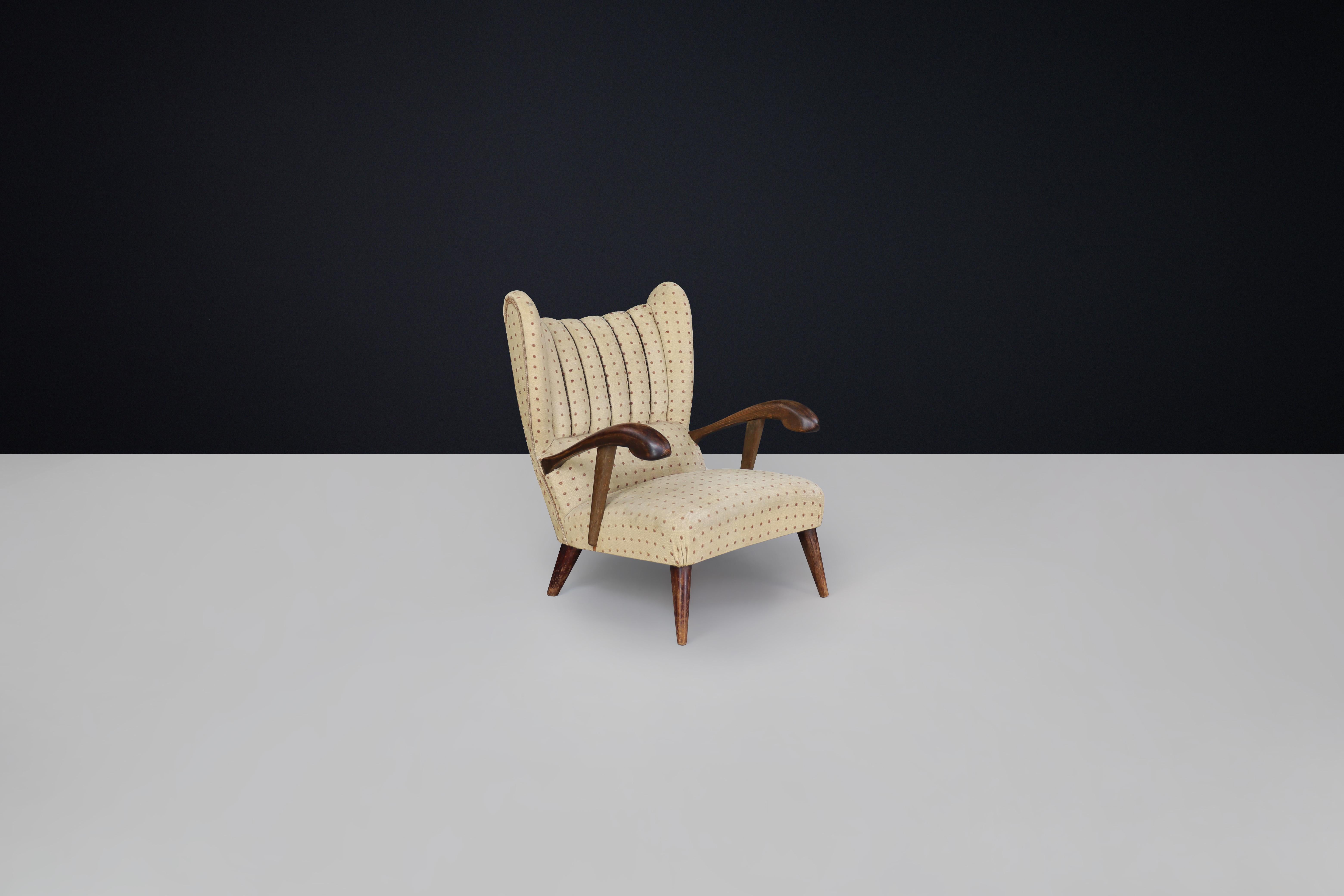 Sculpted lounge chair in walnut with original upholstery, Prague, 1930.

This beautifully crafted sculpted lounge chair from the 1930s, hailing from the Czech Republic, showcases exceptional design and craftsmanship. Its construction features