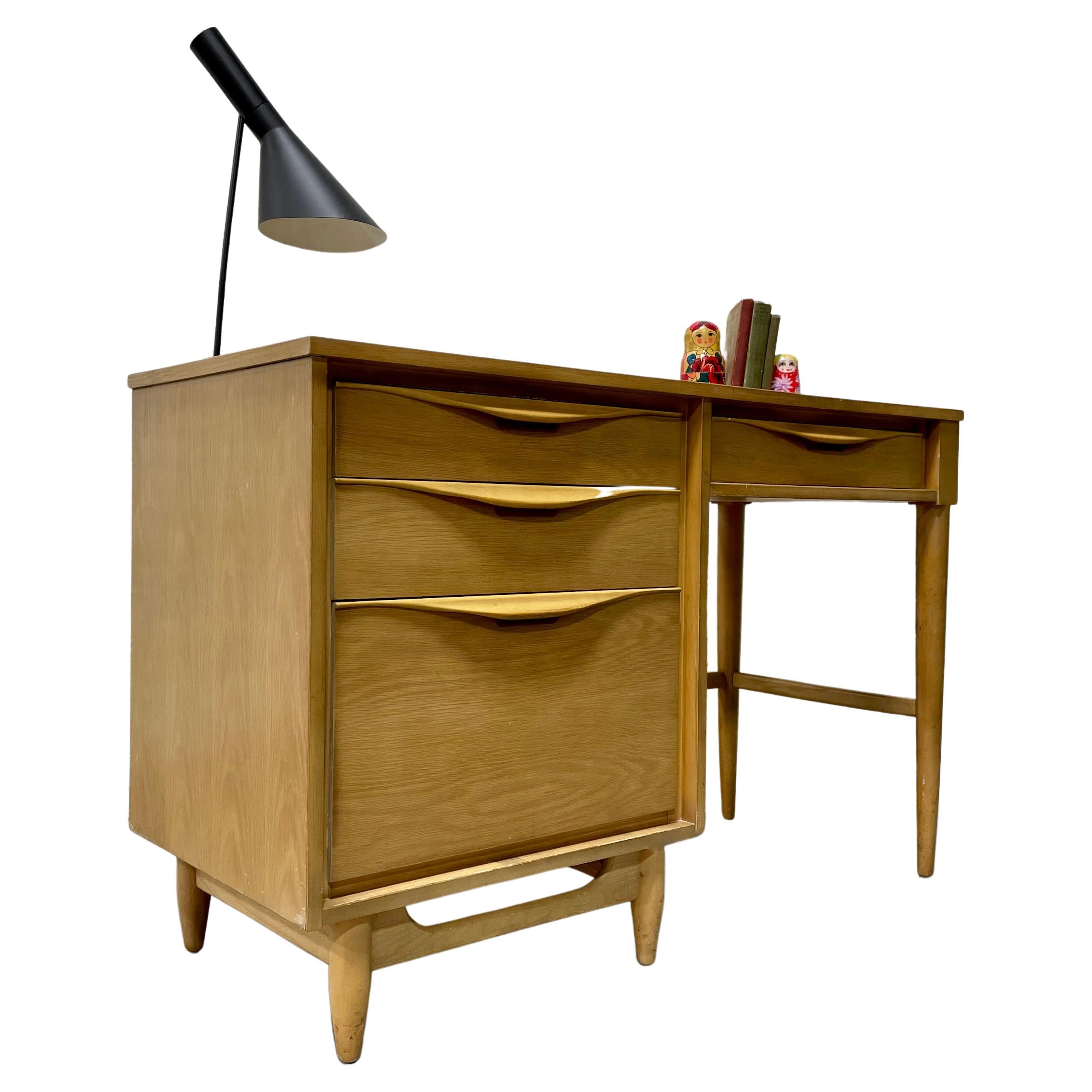 Apartment sized Mid-Century Modern Sculpted Oak Desk, circa 1960s - perfectly sized for an apartment or smaller office space yet offers a generous workspace. This beauty offers four drawers with sculpted hand pulls, including an extra deep drawer.