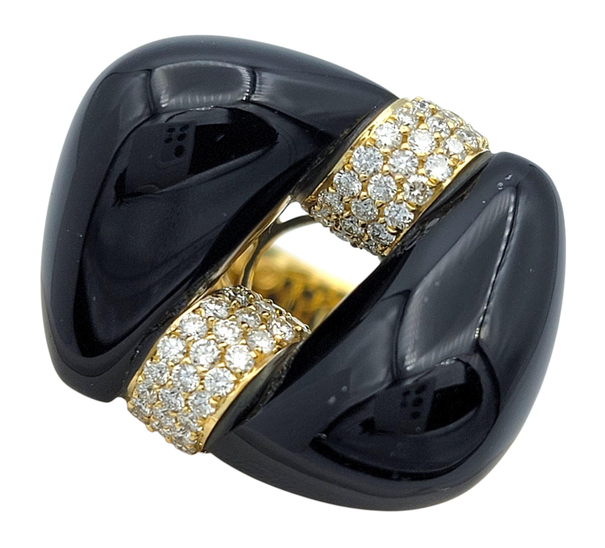 Misura dell'anello: 7

Questo anello scultoreo unisce un'eleganza audace a forme moderne, realizzato in oro giallo 18 carati e impreziosito da un caratteristico centro in onice calcedonio intagliato. Il design ampio dell'onice è intersecato da un
