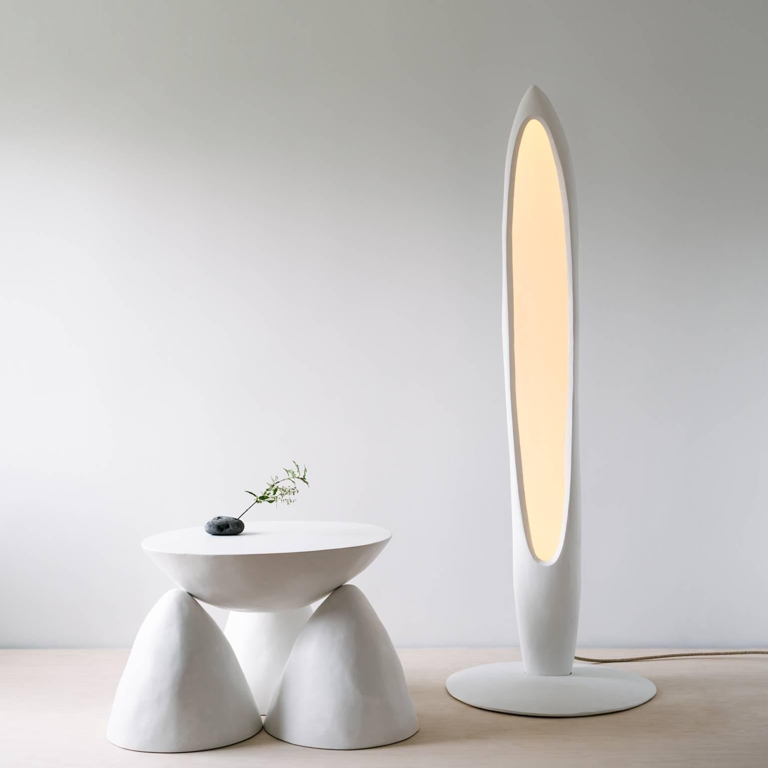 The Oyyo floor lamp is initially cast in plaster and then carved by hand and sealed with lime. 

Its hollow interior has a roughly carved surface with a hidden, dimmable, 3000K LED track which operates remotely with a controller or via phone app.