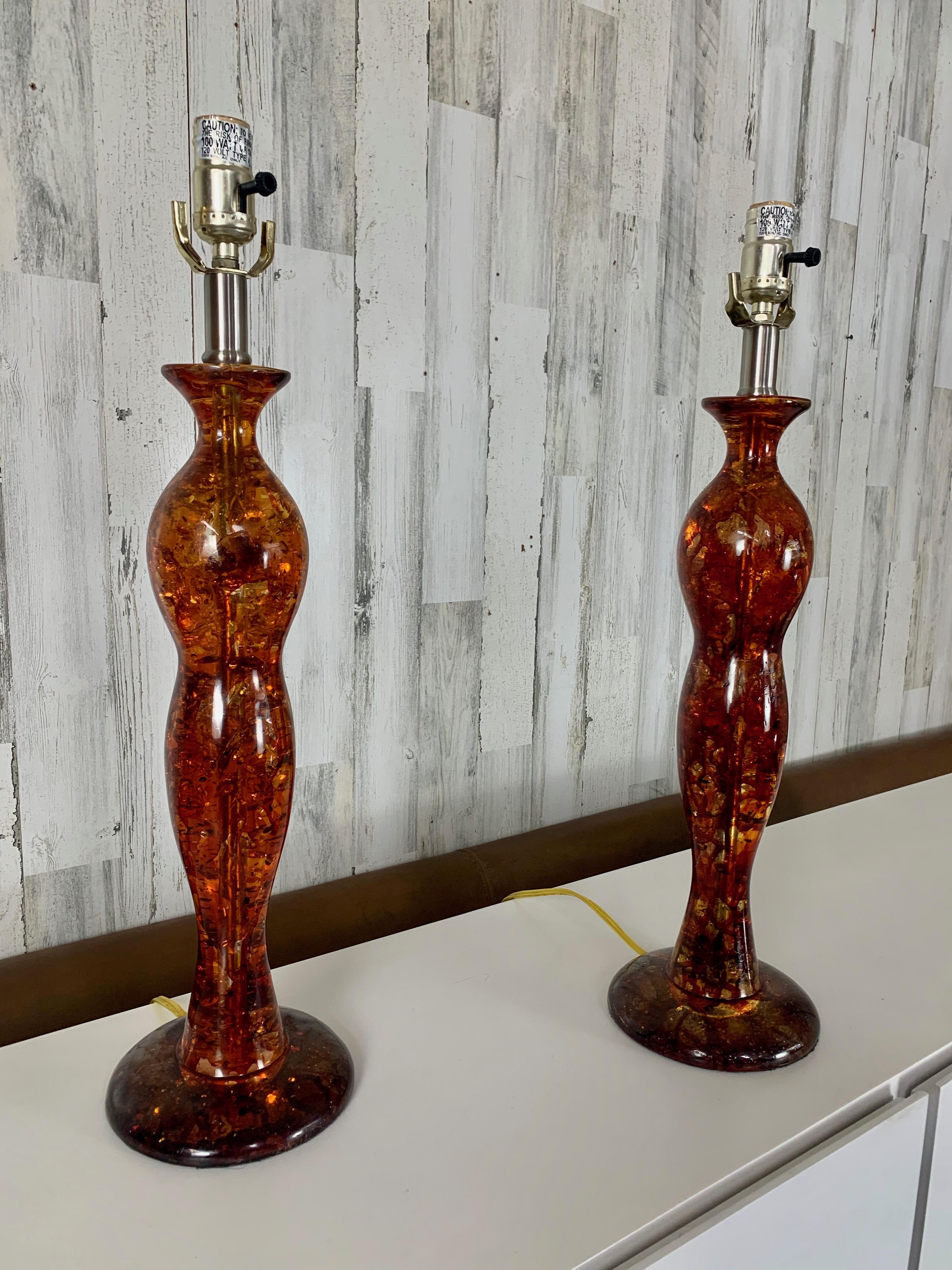 Paire de lampes de table en résine ambre sculptée, au design très libre avec des abat-jours ovales originaux.        Fabriqués par Anthony California Inc. Abat-jours facultatifs dont l'un présente une légère perforation. La hauteur au sommet de la