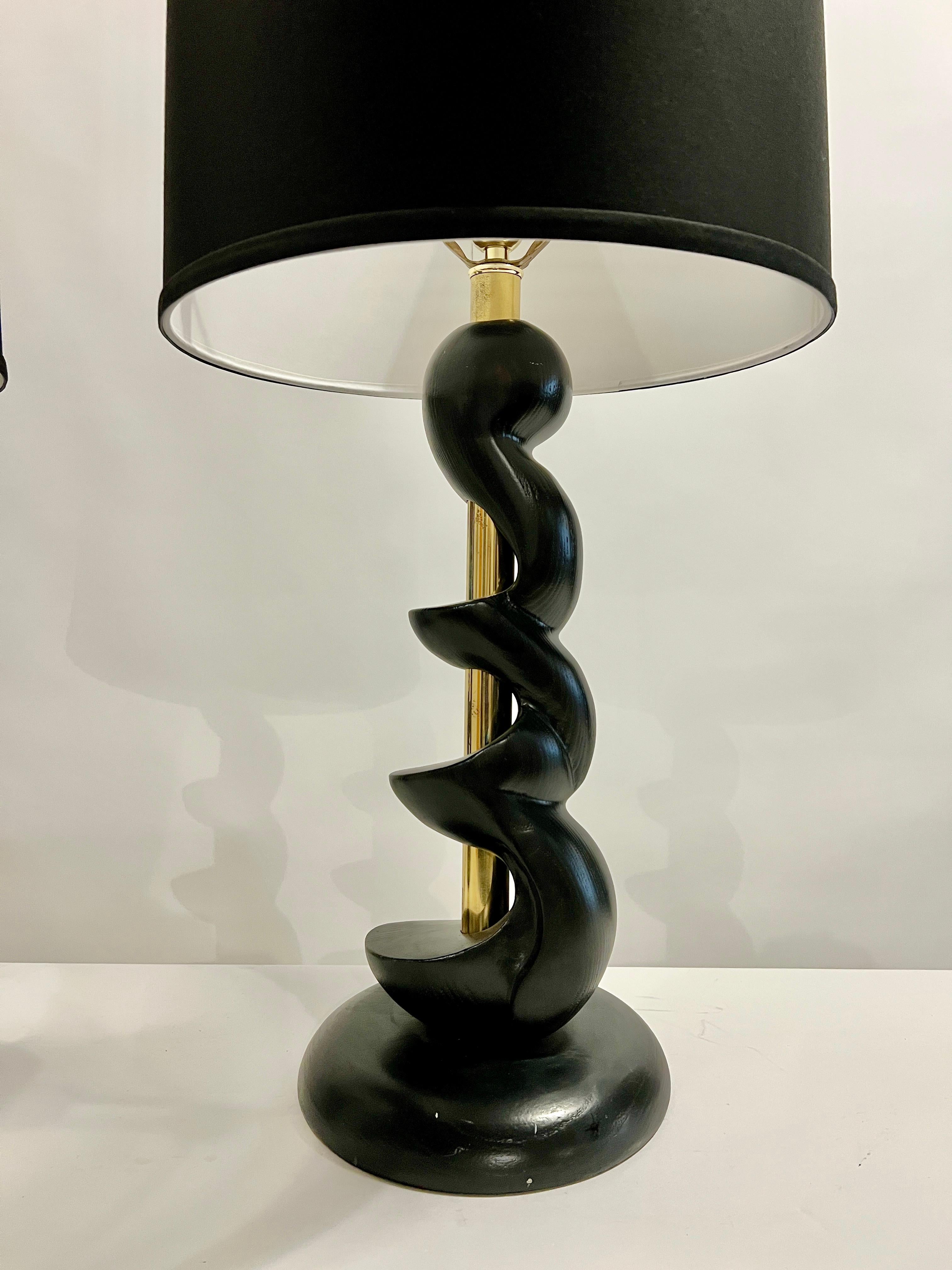 Elegant pair of spiral sculpted ebony wood lamps with brass accents. These vintage lamps were made by Light House Light and Shade Co., Los Angeles, Ca. in the 1960's and reinvented more recently in lacquered black. Lamps are in good working order. 