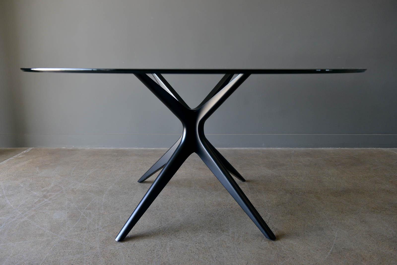 Sculpted star base dining table with floating glass top, circa 1970. Professionally restored in gloss black. Glass is in very good vintage condition with hardly any wear. Very reminiscent of Adrian Pearsall jacks table, however unmarked.

Measures: