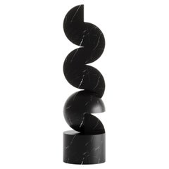 Totem in marmo nero con volute scolpite