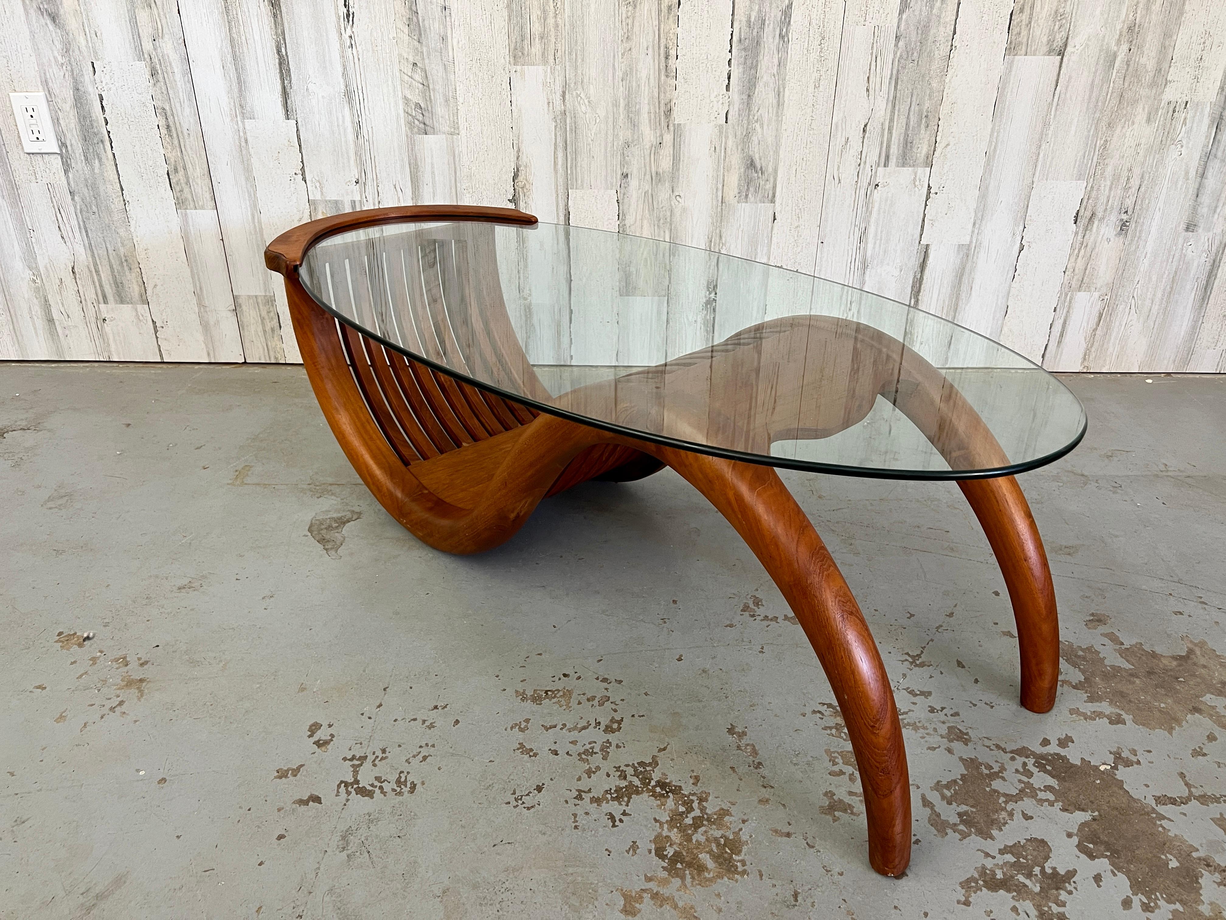 Base en teck sculpté de style moderne danois en forme de vague avec un plateau en verre ovale.