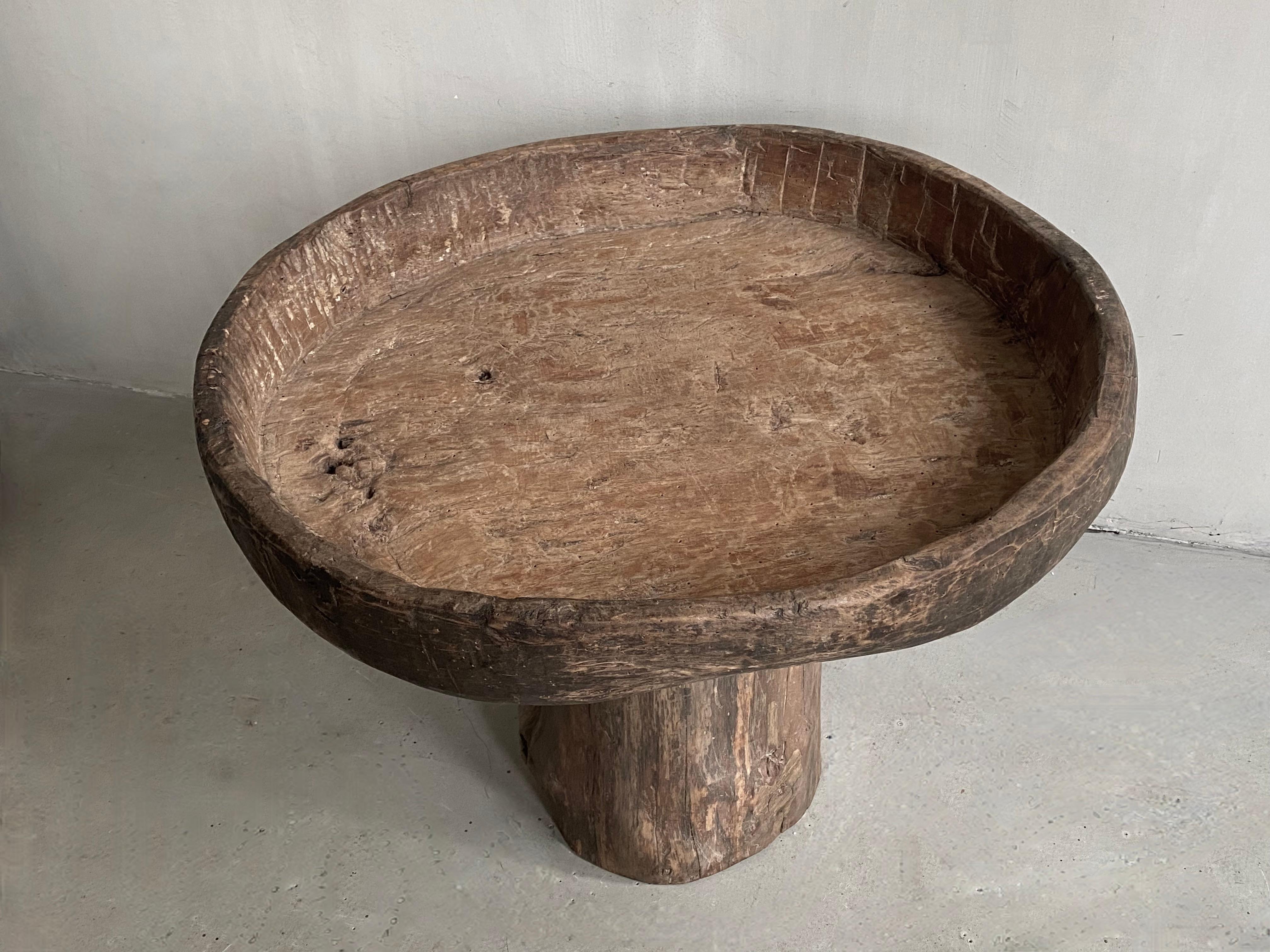 This unique side table is composed of an exceptionally beautiful old XL platter and a an old base in solid Pine carved wood. 
It gives a warm simplistic feeling due to the beautiful use patina of the original old bowl.
A piece of which there is no