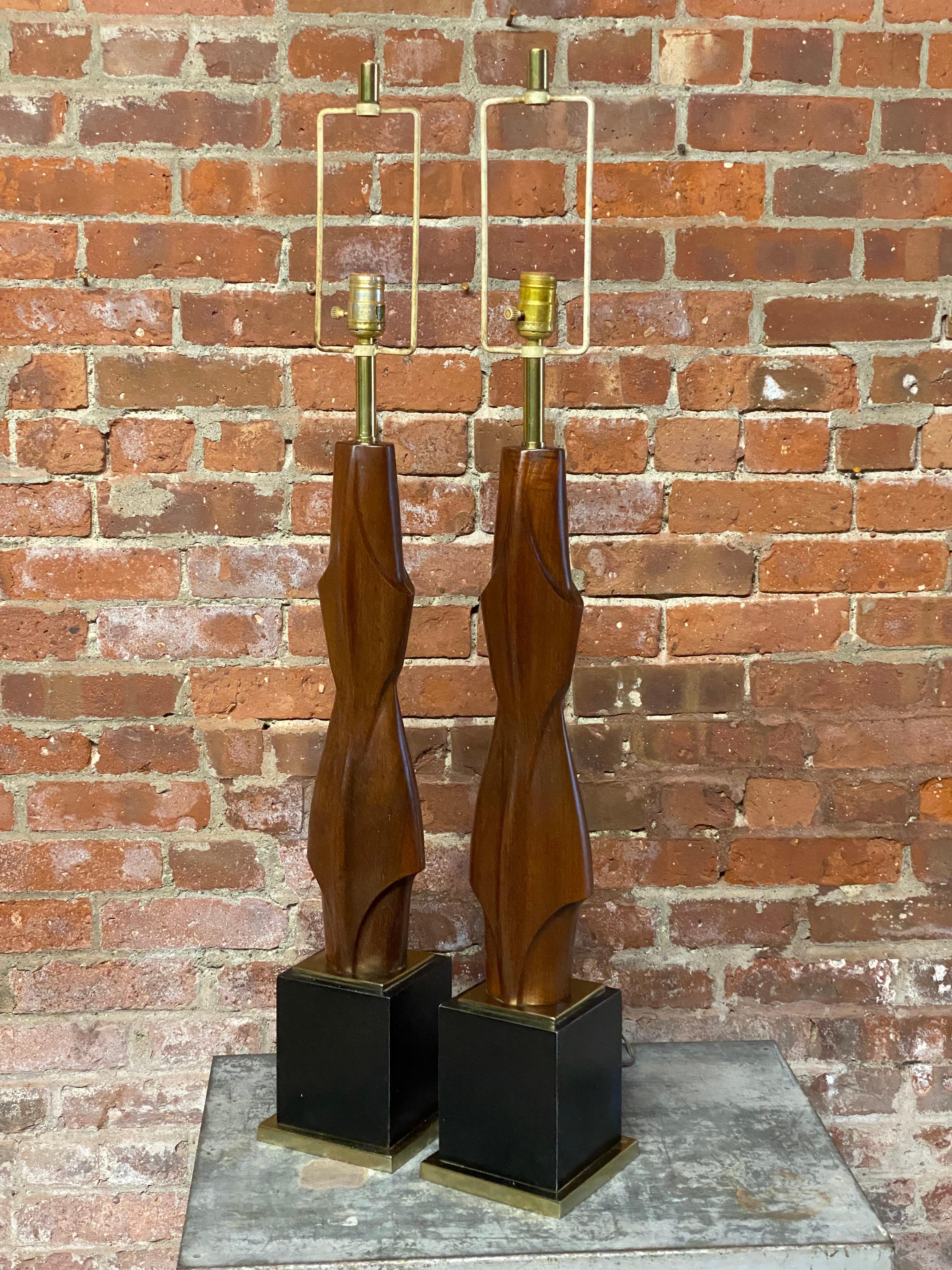 Ein wunderschönes Paar geschnitzter Tischlampen aus massivem Nussbaumholz Laurel. Die formschöne und geschwungene Gestaltung macht die Tischleuchte zu einer skulpturalen Kunstform. Jedes Beispiel enthält das Label auf jeder Lampenfassung, Laurel