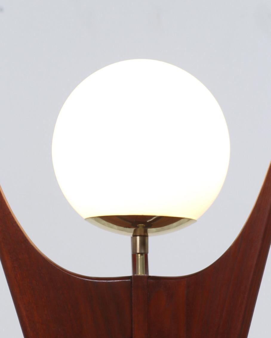Stylish sculpted modern table lamp designed and manufactured by the workshop of Danish Modern LA. This 3-dimensional desk lamp features a sculpted walnut wood body with three vertical prongs that are joined at the bottom that holds a brass canopy to