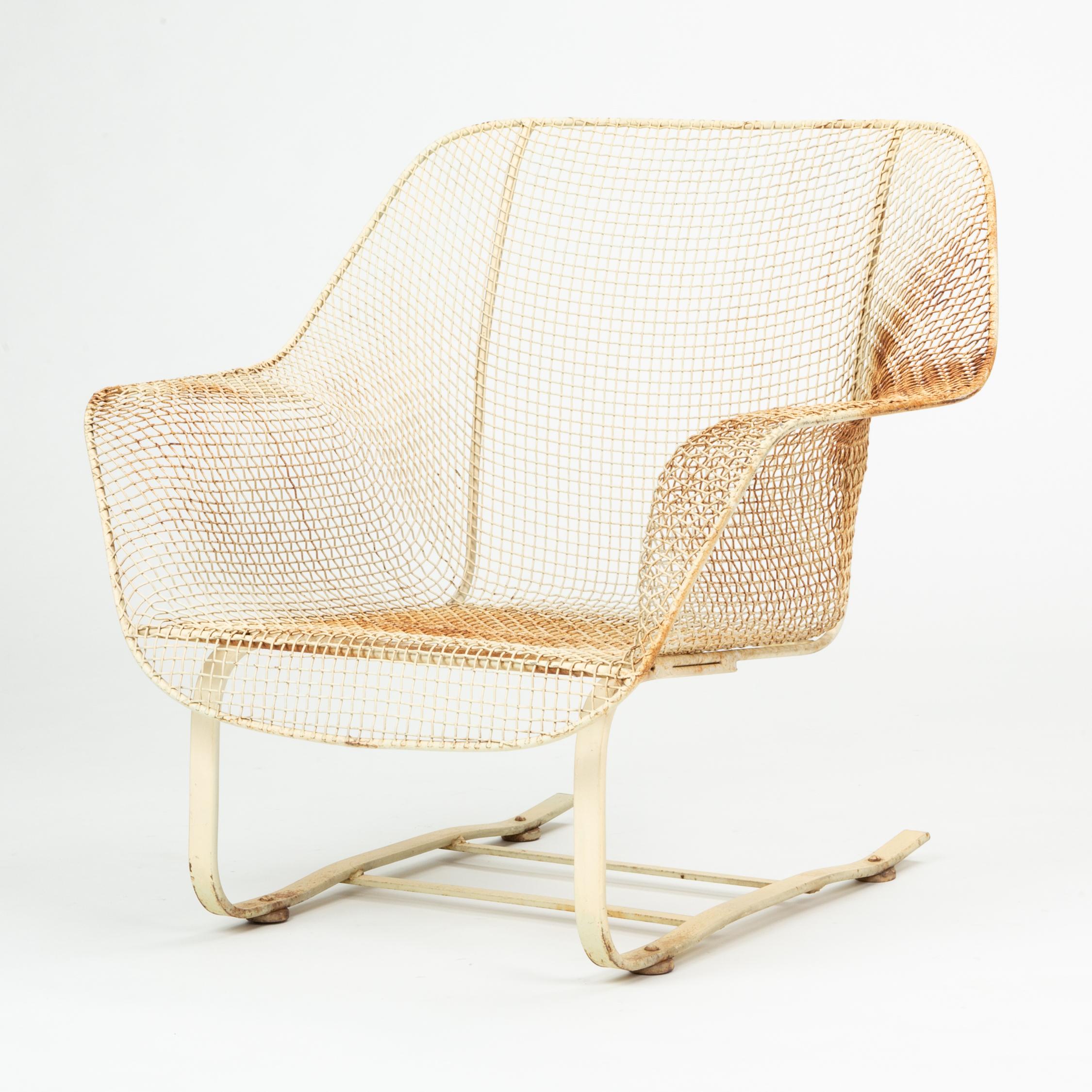 A rocking lounge chair from Russell Woodard’s 1956 Sculptura collection for his family company, Woodard Furniture. The low chair has the collection's signature molded wire mesh seat and its cantilevered base with two runners provides the rocking