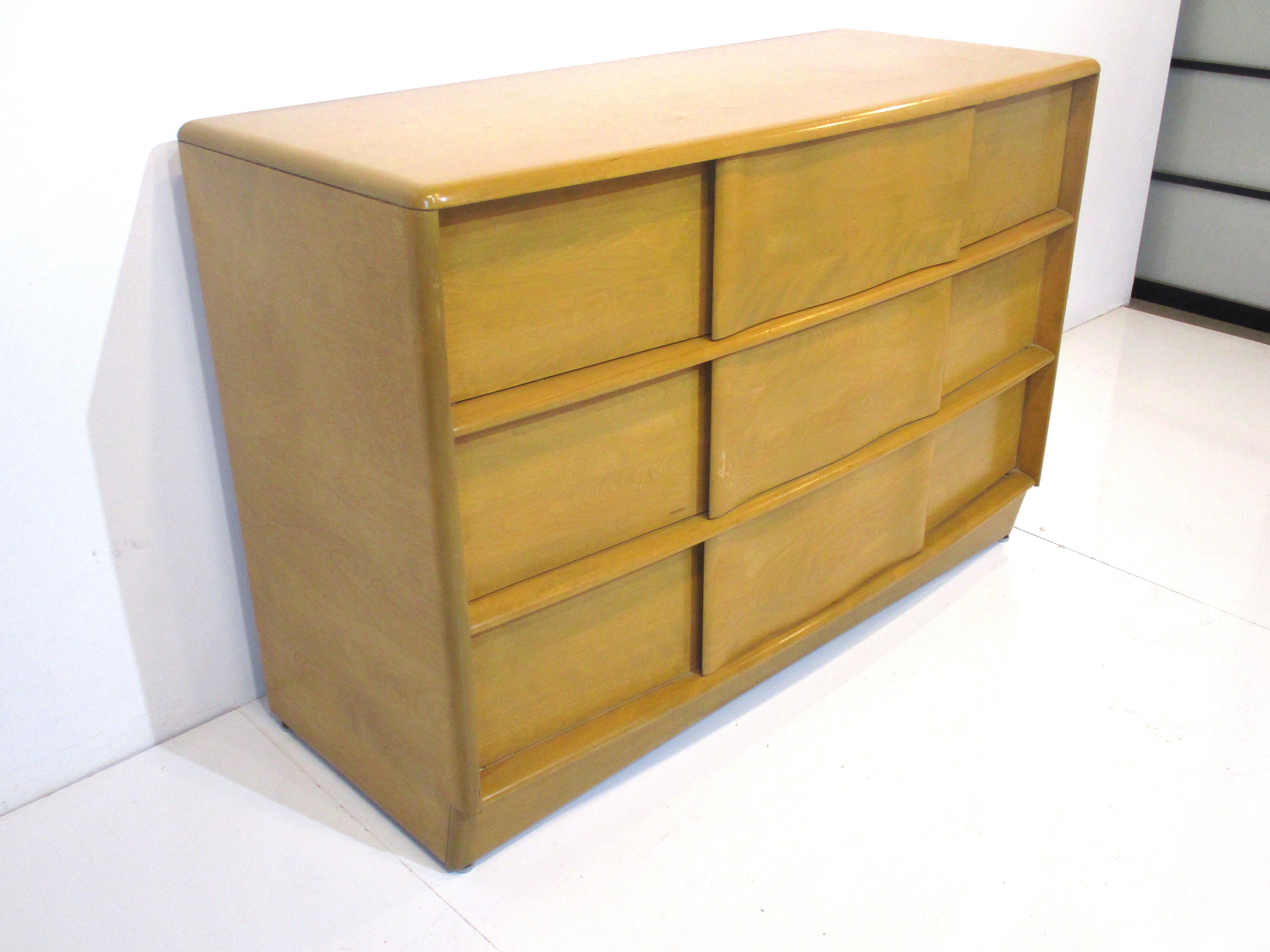 A solid maple small scaled single three drawer dresser chest with sculptural ribbon flowing designed drawer fronts . The handles are integrated into the drawers leaving the lines of the chest very clean from the Sculptura Collection model number