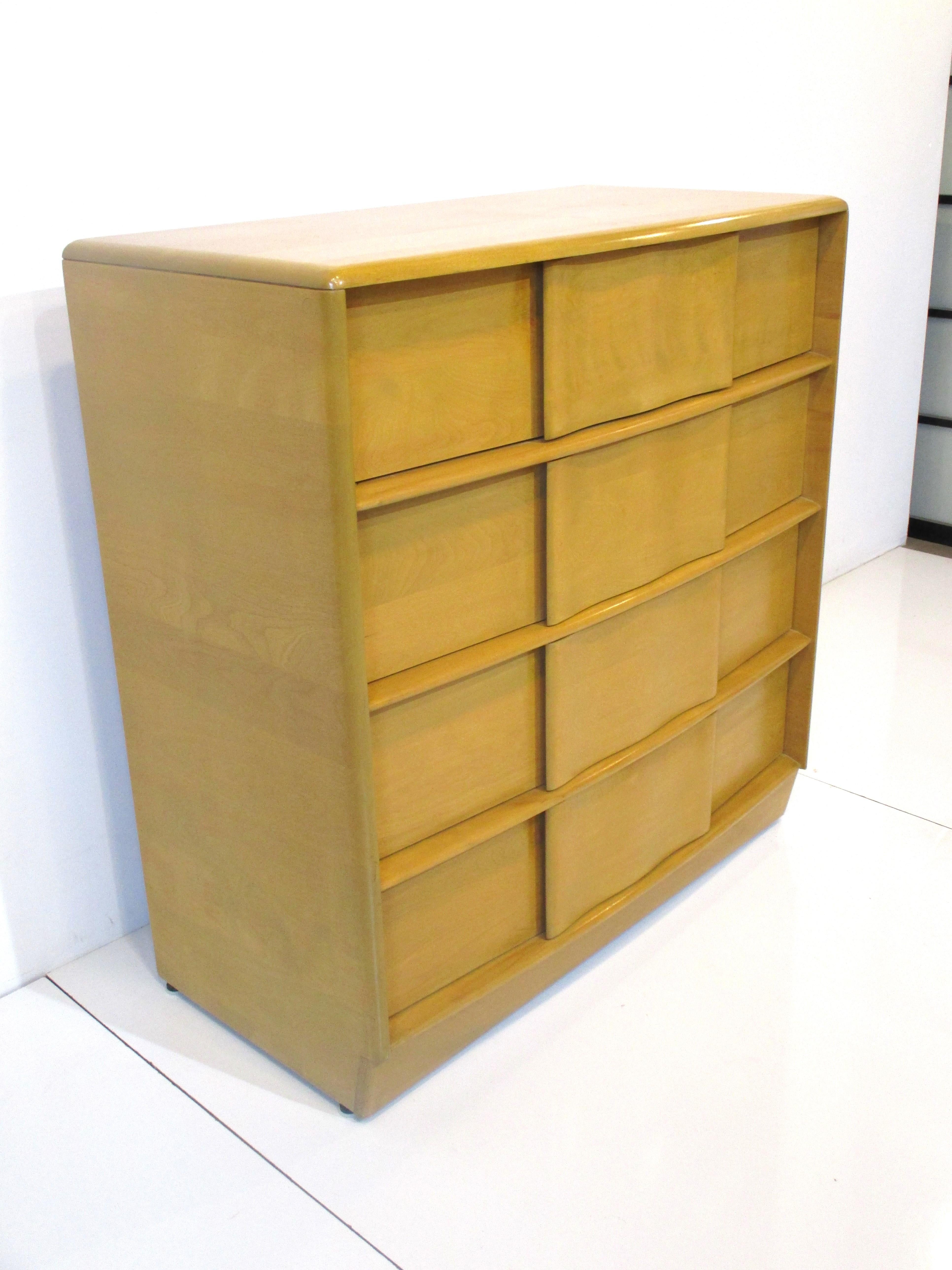 A solid maple wood tall four drawer dresser chest in a smaller scale with ribbon like sculptural drawers. The handles are integrated into the front making for a very clean aesthetic, designed by Ernest Herrmann and Leo Jiranek from the Sculptura