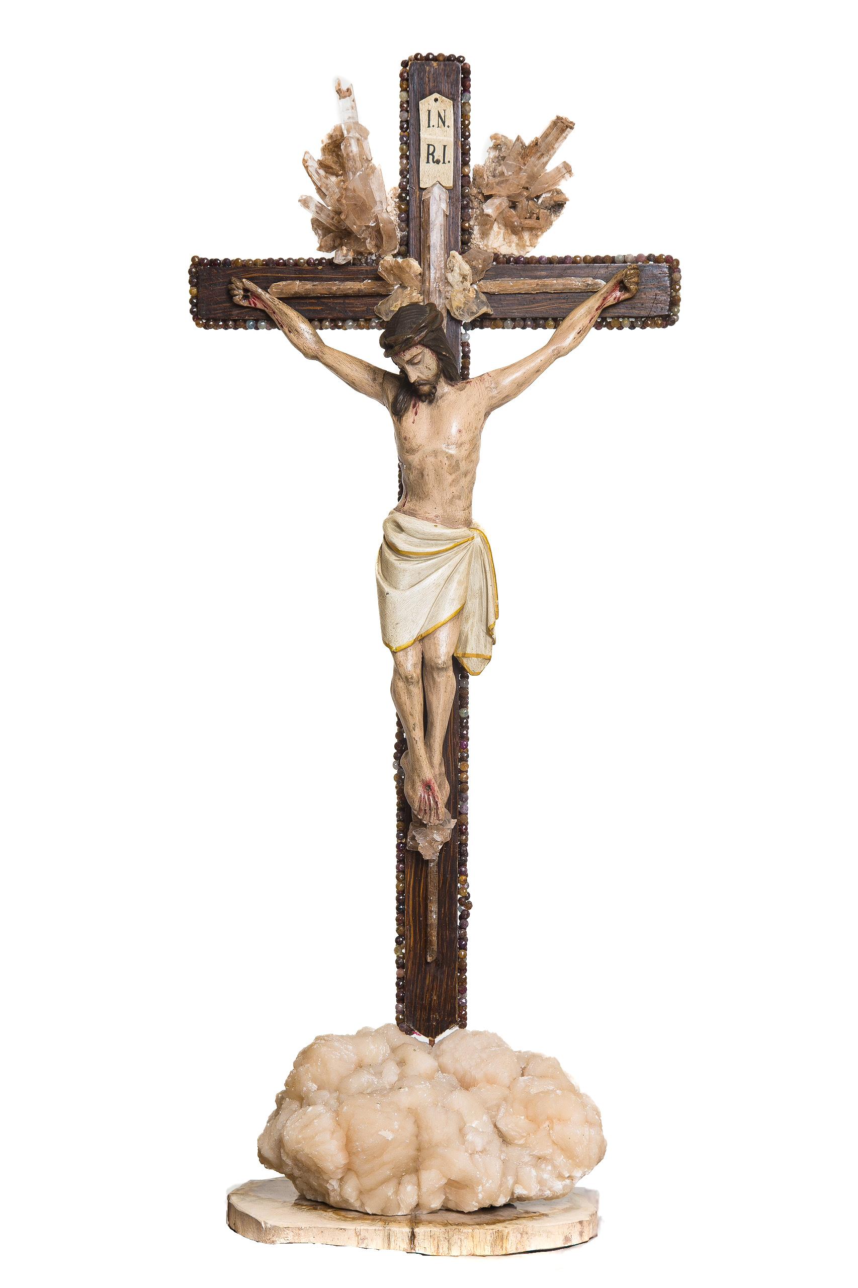 Sculptural 18th century Italian crucifix with selenite in matrix and adorned with gem beading around the cross. The selenite in matrix creates the sunrays around the crucifix. The piece is mounted on apophyllite and petrified wood.

The piece is put