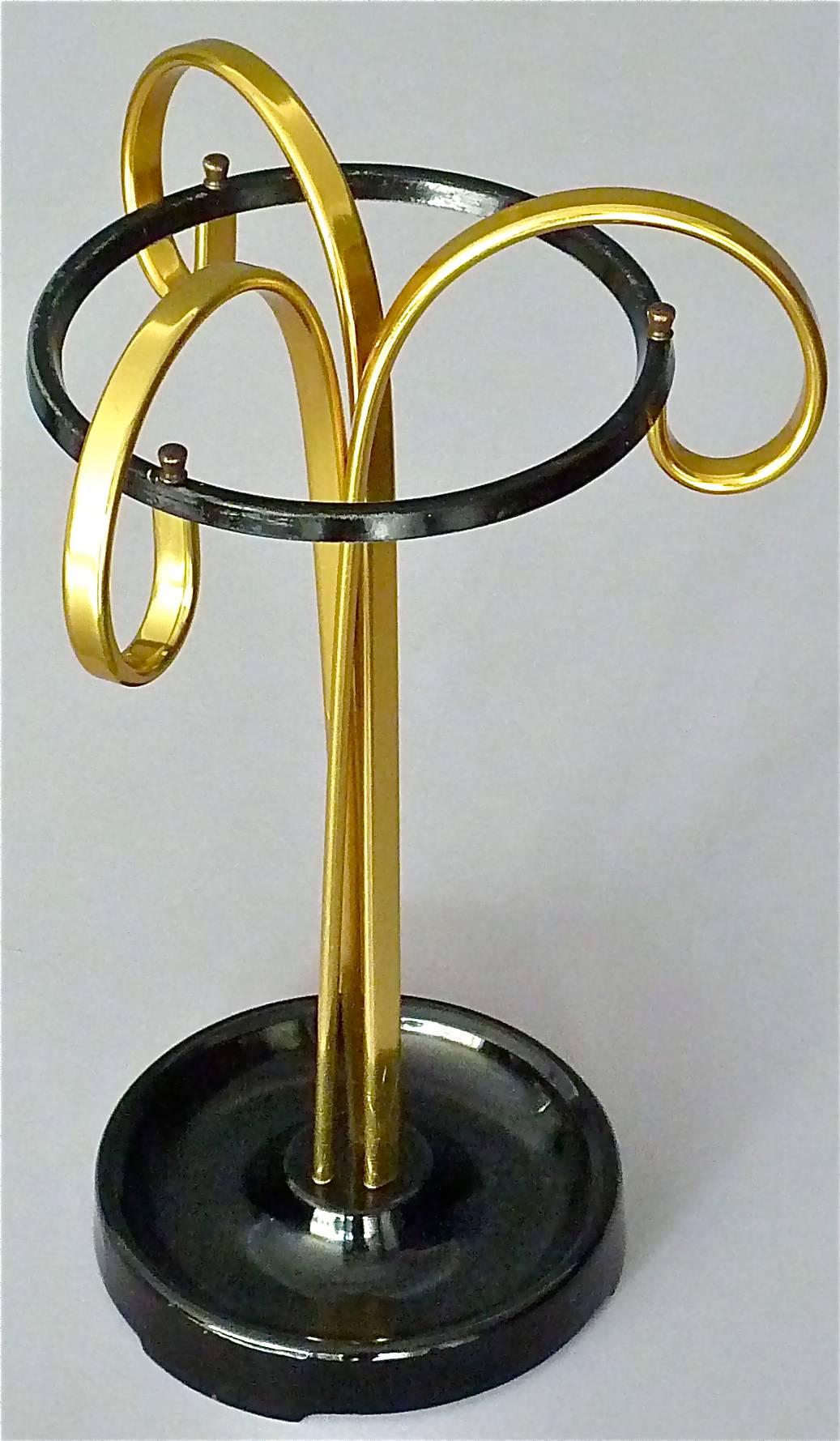 Unusual sculptural midcentury umbrella stand designed and executed in the 1950s probably in Germany, Austria or Italy. It is made of three golden color anodized aluminum metal rods which are up-going slightly twisted, ending scrolled and holding a